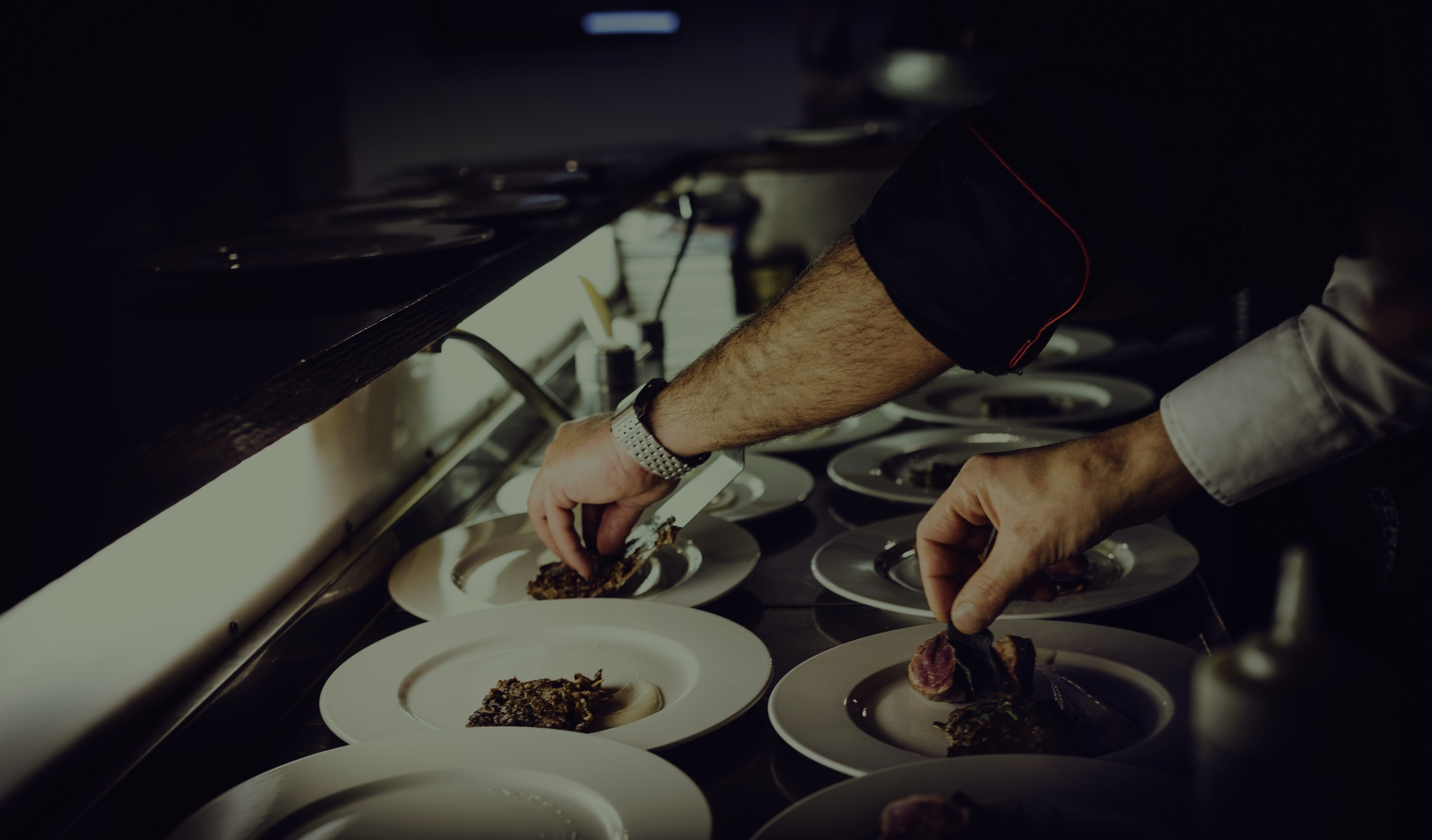 Chef plating dishes in a commercial kitchen service line