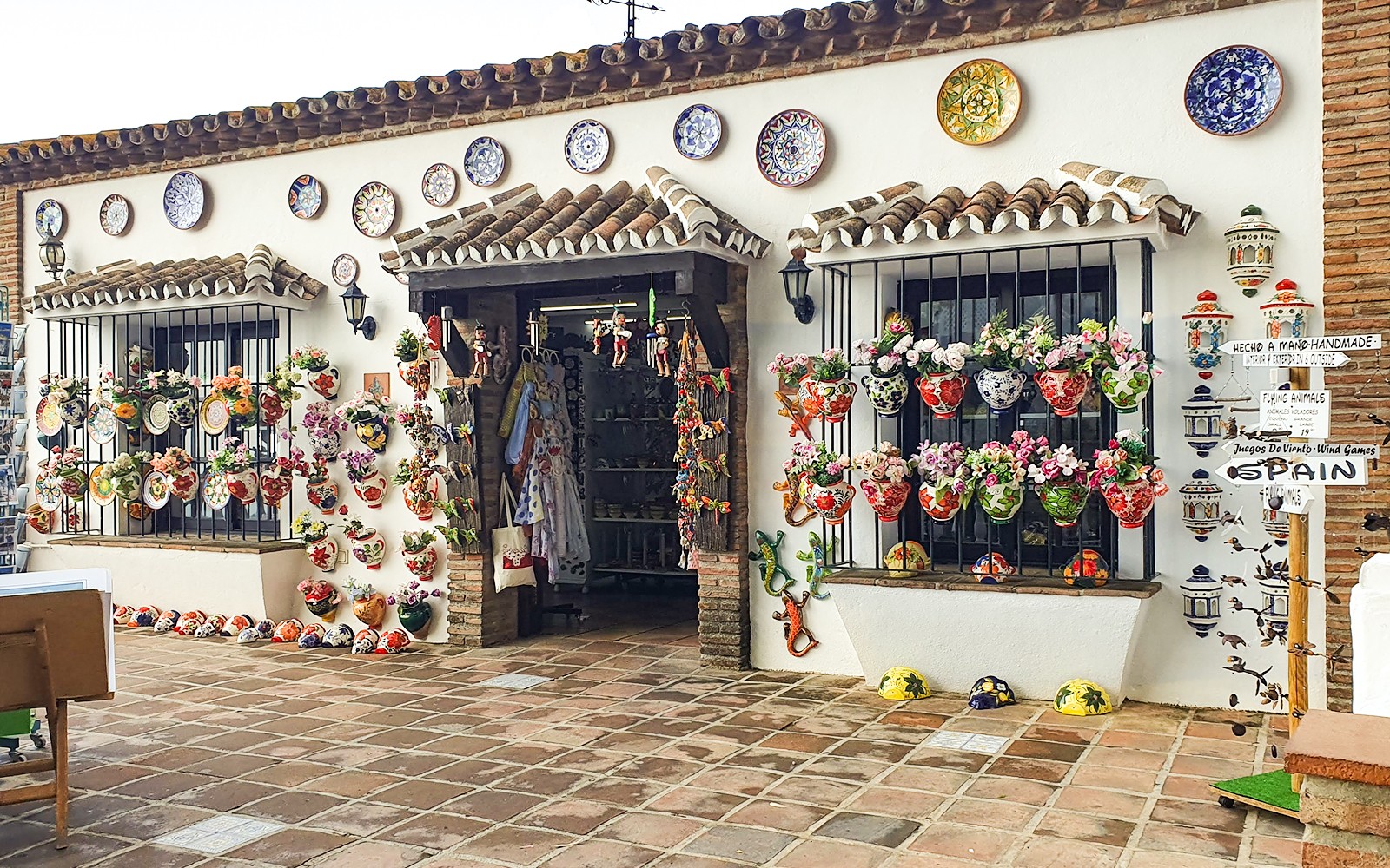 Ceramic shop with colorful pottery and floral displays in Mijas, Spain.