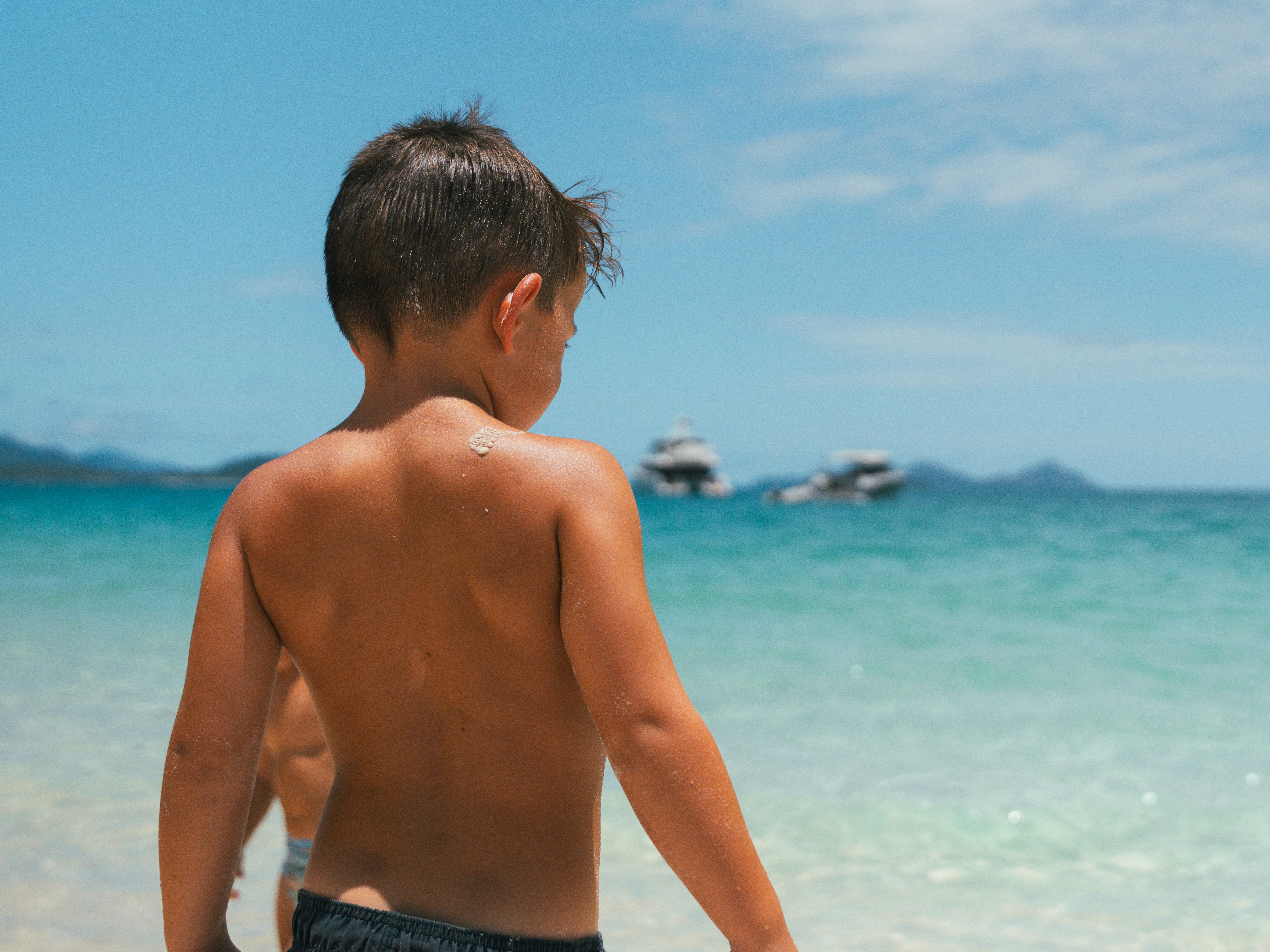 Portrait of a laughing person with curly hair wearing a white shirt