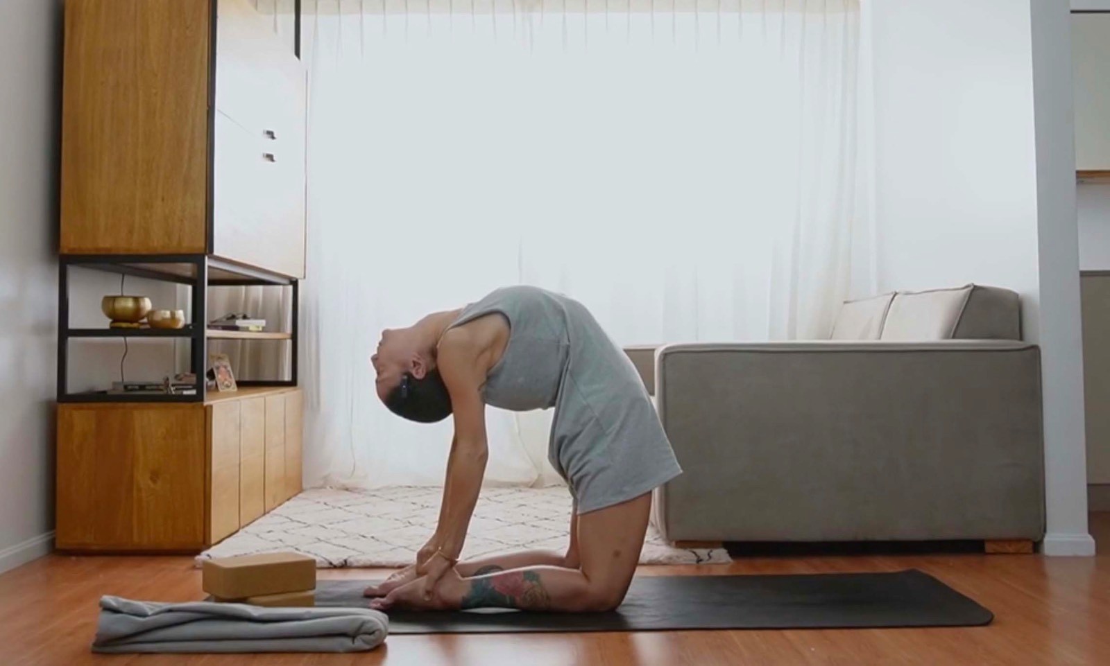 Flavia Siutti realizando una postura de yoga con extensión hacia atrás sobre una esterilla.