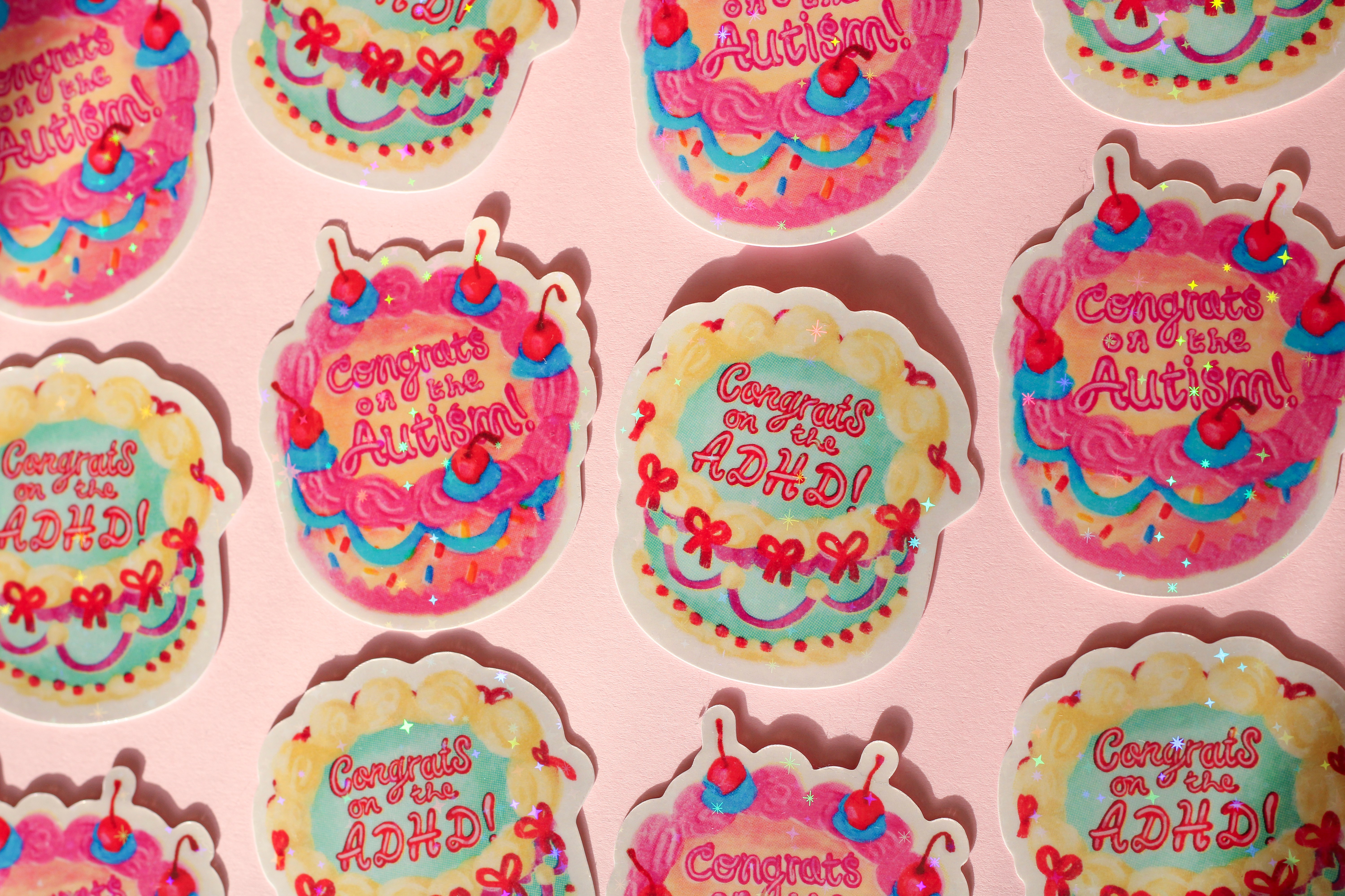 The two cake designs in sticker form. They have a sparkly finish.
