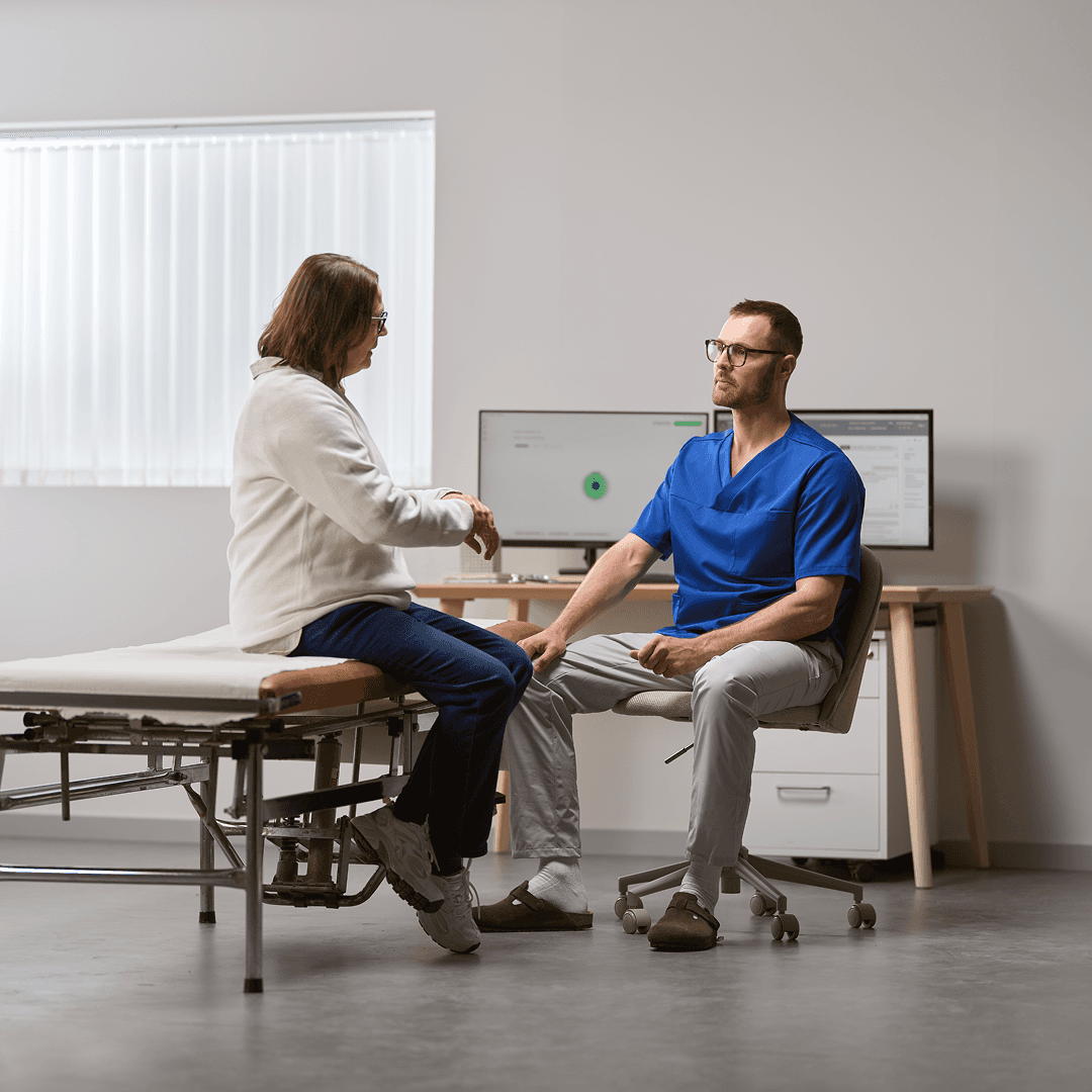 A clinician consulting a patient at the desk during a visit.