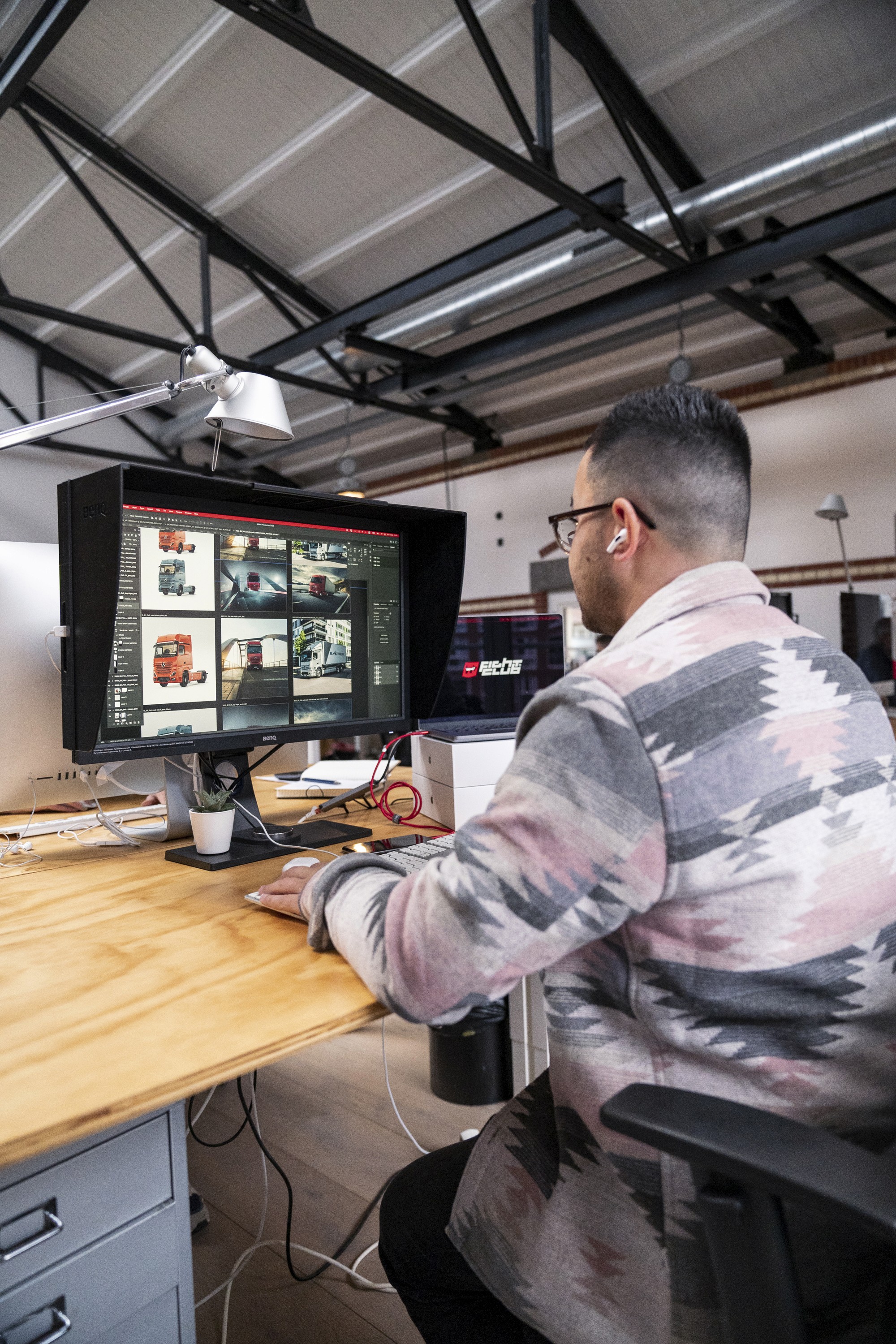 a man working at a desk looking at a monitor