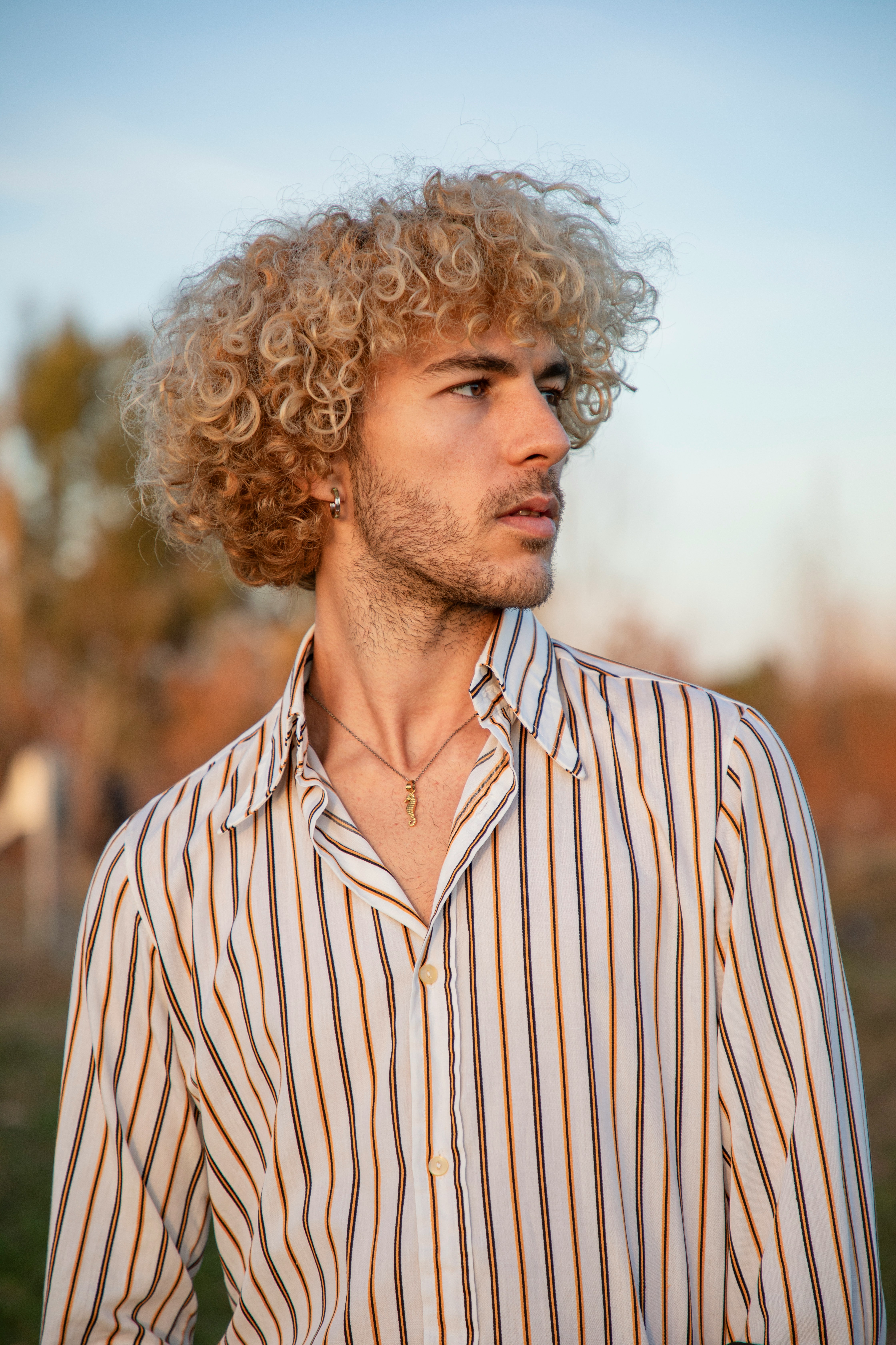 a man with curly hair wearing a striped shirt