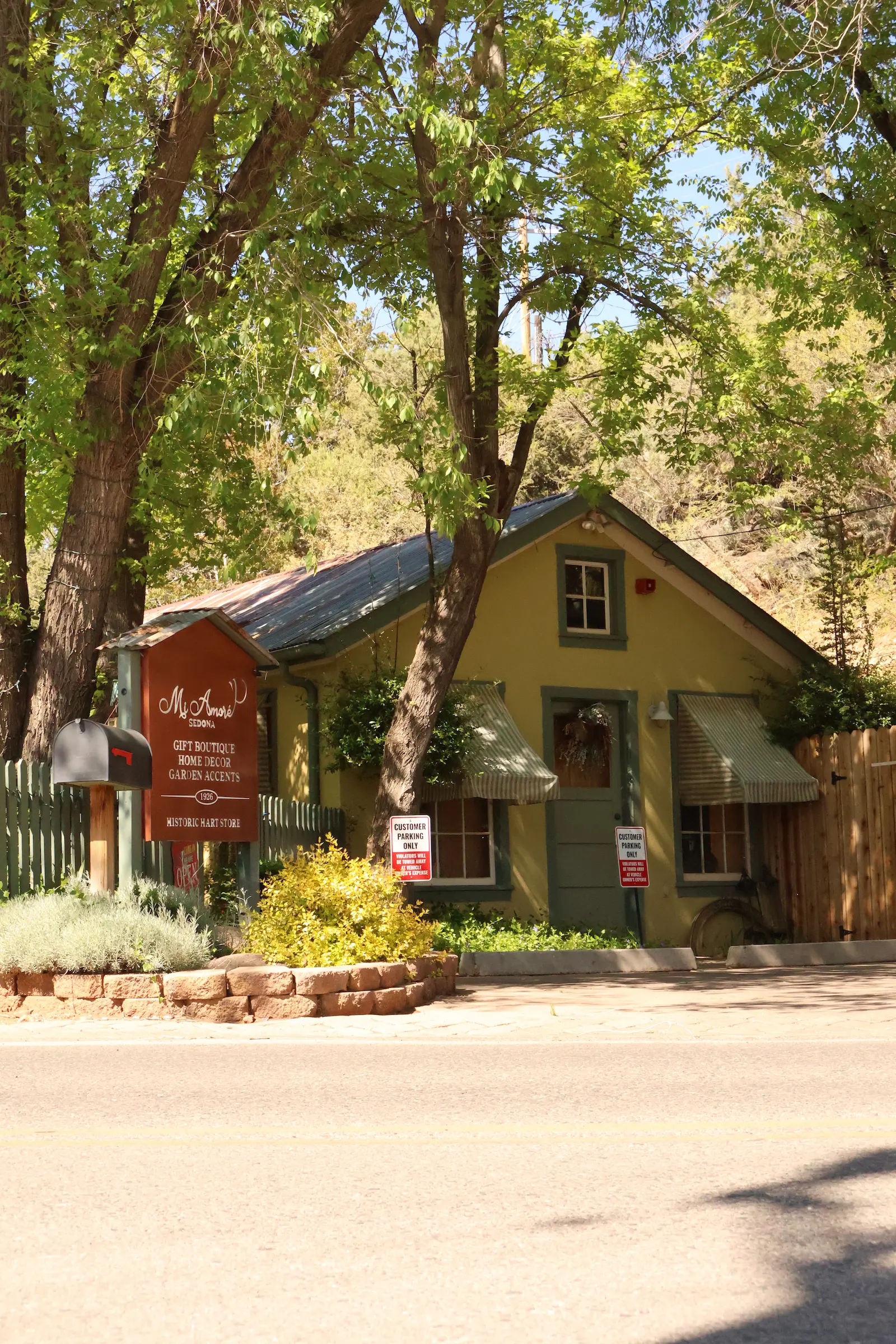 Front of Mi Amore Sedona gift shop in Sedona Arizona, featuring historic Hart Store signage, lush garden setting, and ‘Cutest Gift Shop’ display at the entrance