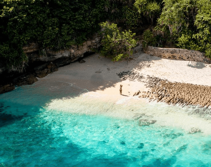 Turquoise waters and traditional wooden boats on the beach of Nusa Lembongan, Indonesia