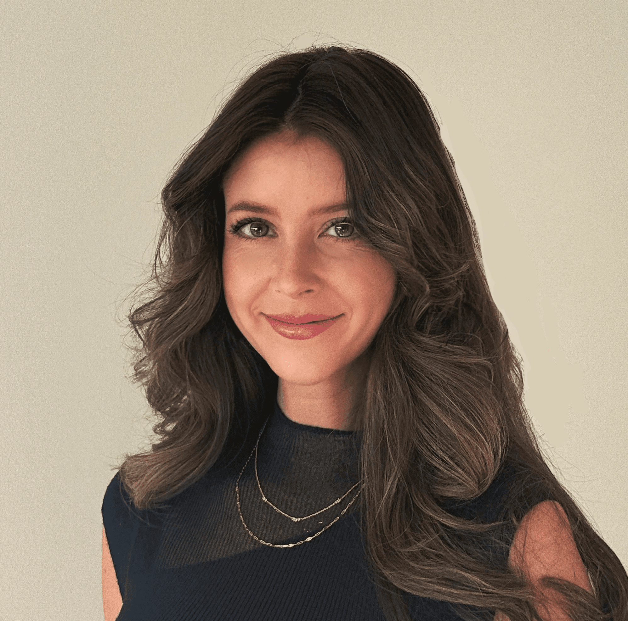 A woman with long brown hair and silver earrings smirking at the camera