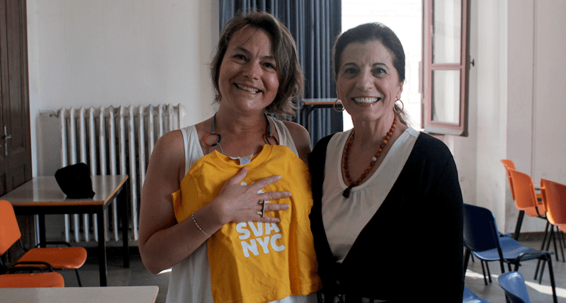 Woman holding a yellow SVA t-shirt