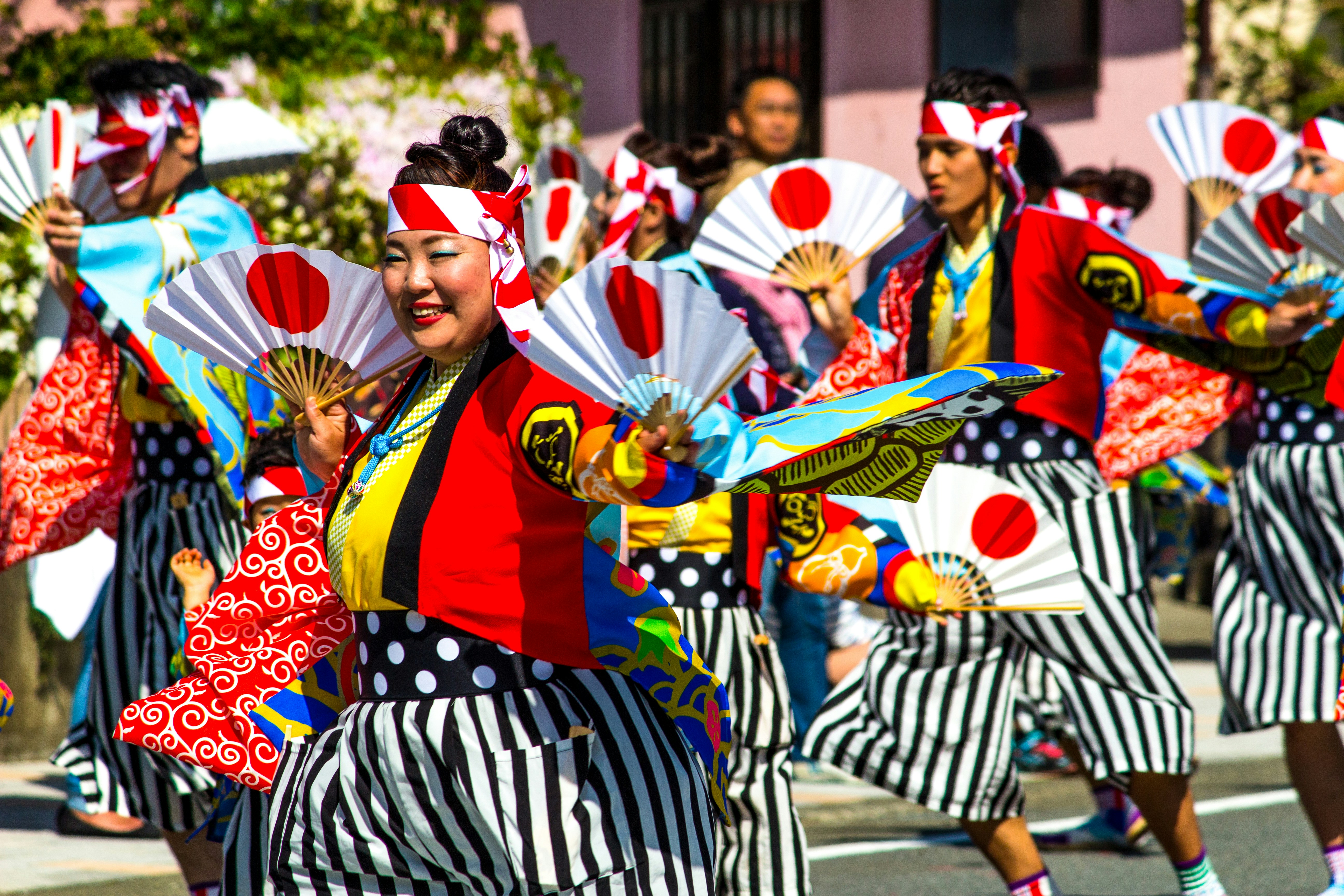 people in red and black traditional dress standing on street during daytime