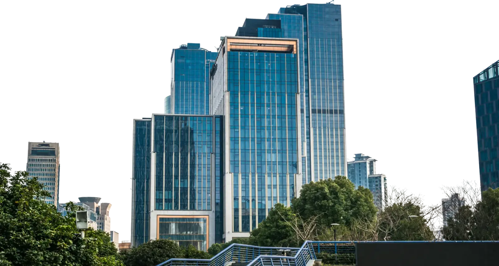 Modern glass office towers rising behind trees