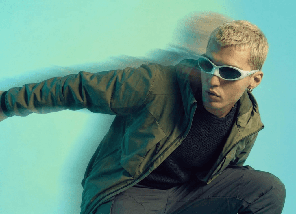 Person wearing sunglasses leaning forward in a motion blur studio shot