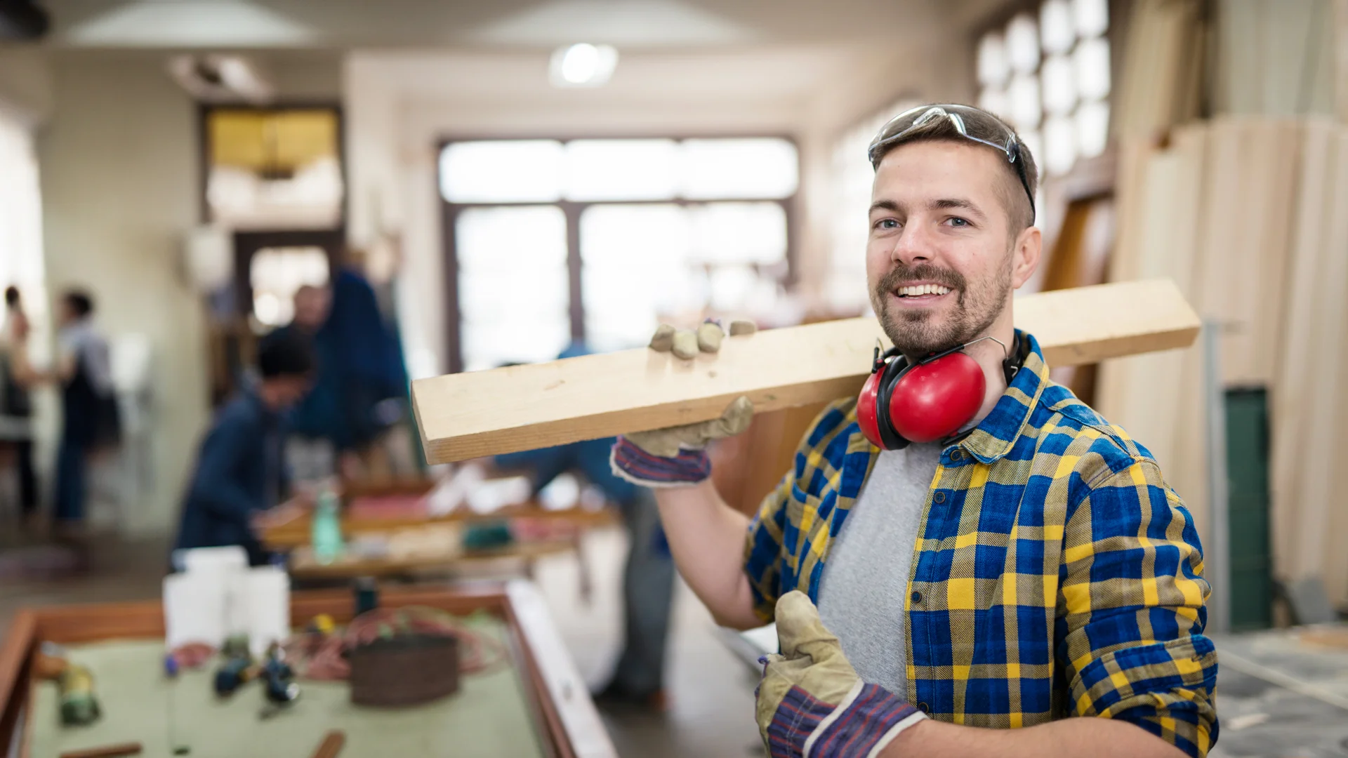 north brisbane property maintenance handyman holding wood with safety gear on