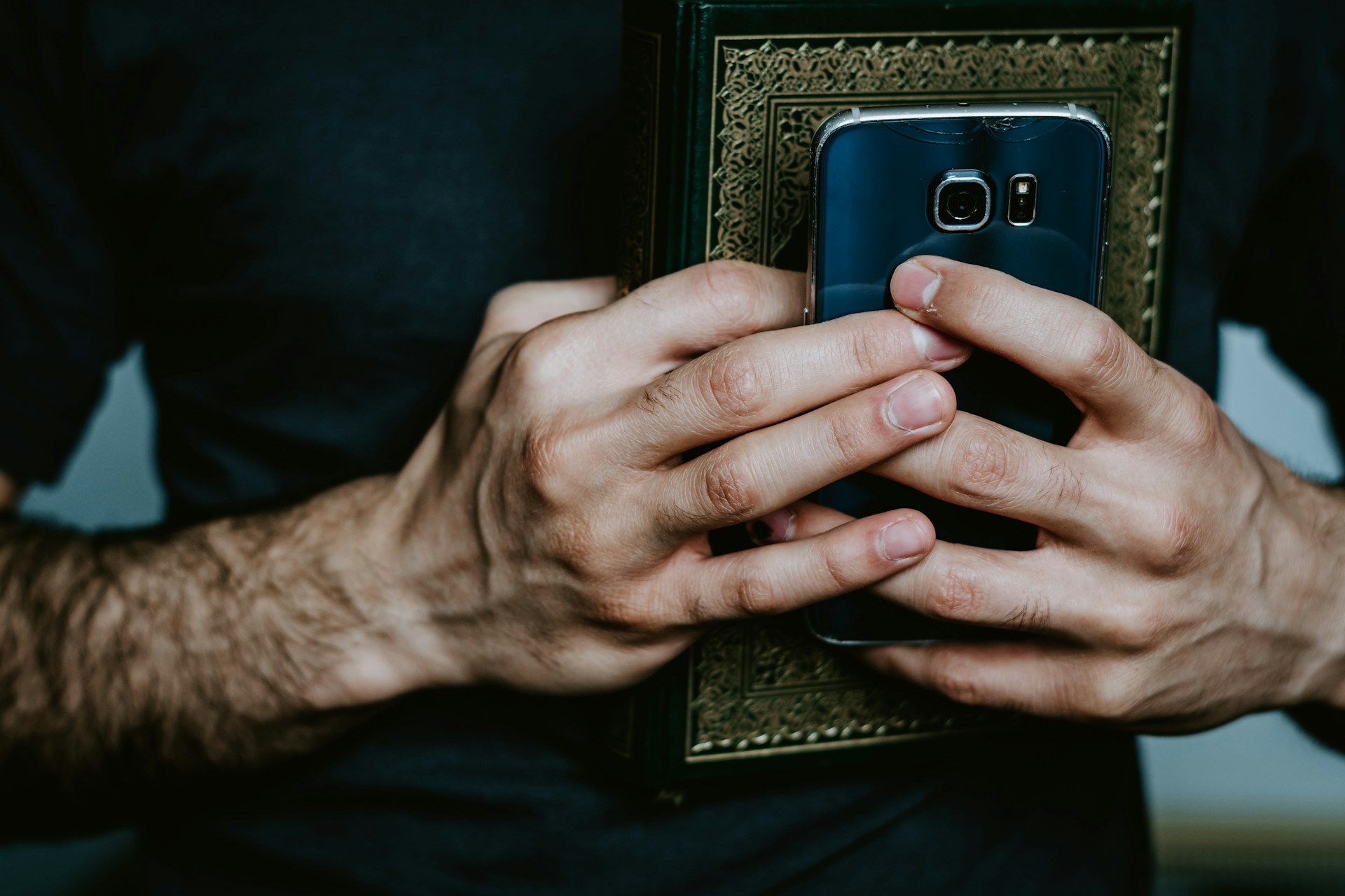 Person holding a Bible & smartphone