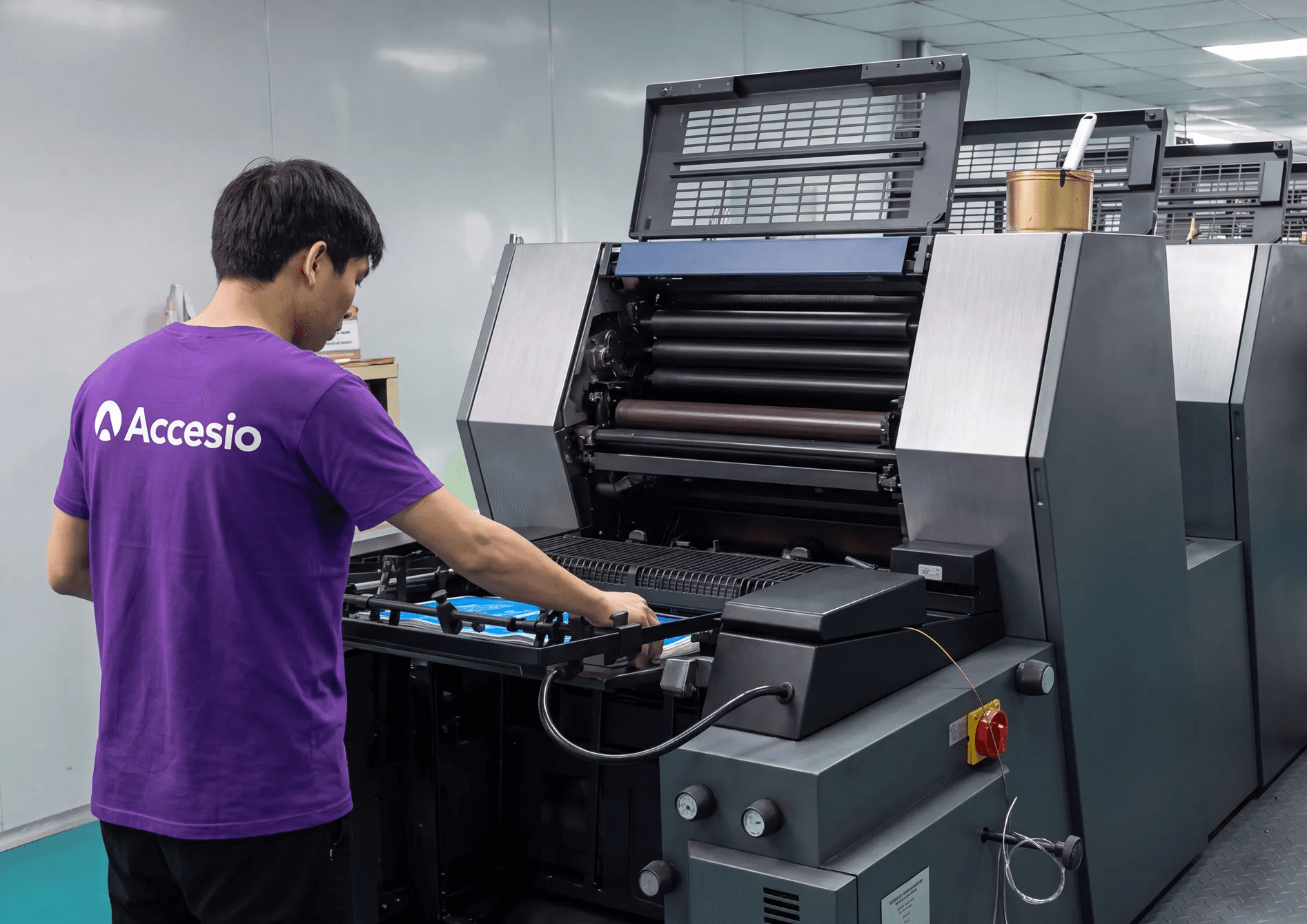 Accesio operator running the offset press where event credentials are printed