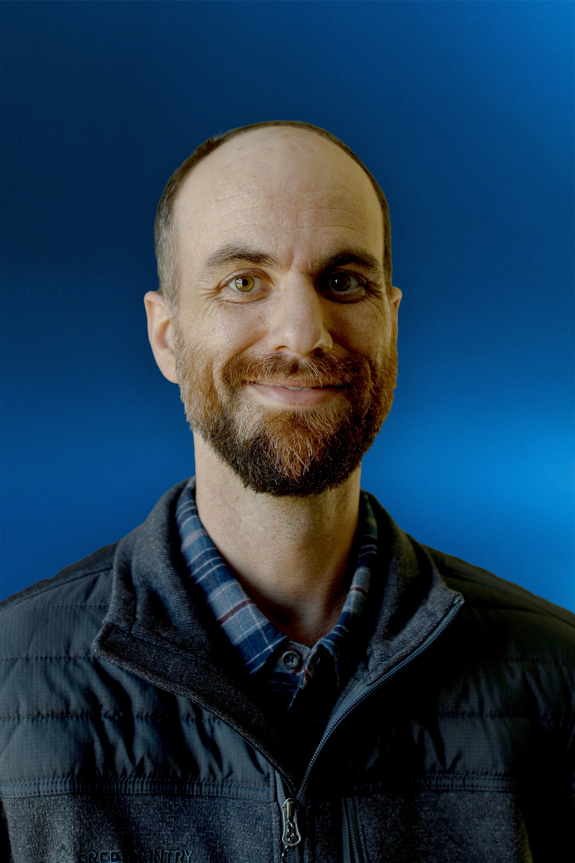 Portrait of a person in dark clothing speaking on a phone