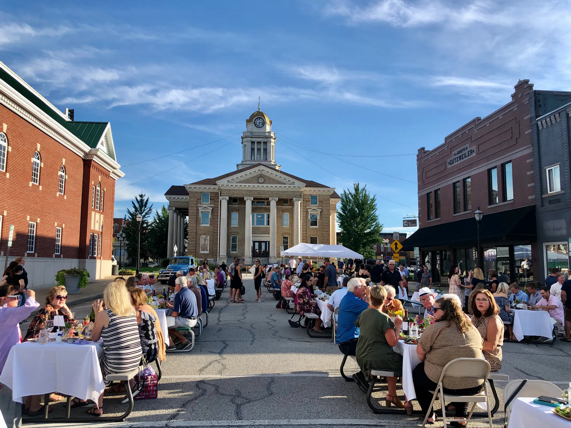 Aerial view of an intersecting dirt pathway forming an X-shape surrounded by lush greenery and arid, rocky terrain, illustrating a contrasting landscape.