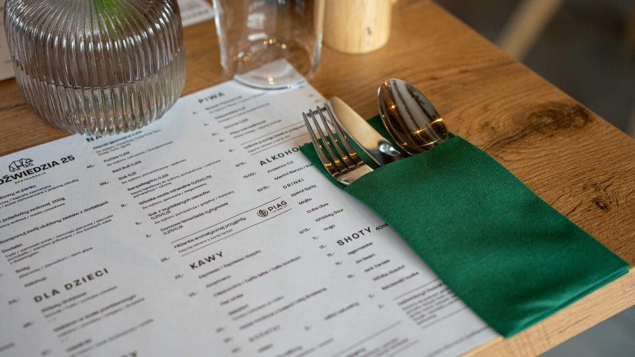 Menu i eleganckie nakrycie stołu w restauracji Niedźwiedzia 25 jako część pakietu aktywnego w IronResorts