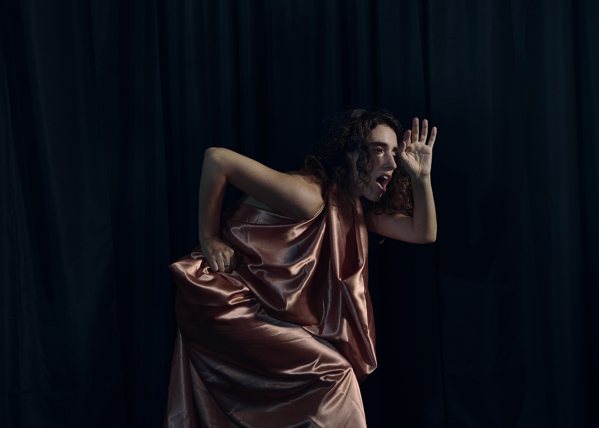 Dancer captured mid performance with artistic and expressive movements against a dark background.