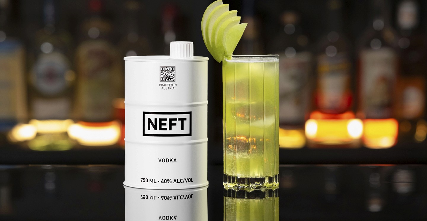 A NEFT Vodka Barrel and a glass of Vodka Pastel Spritz on a bar counter.