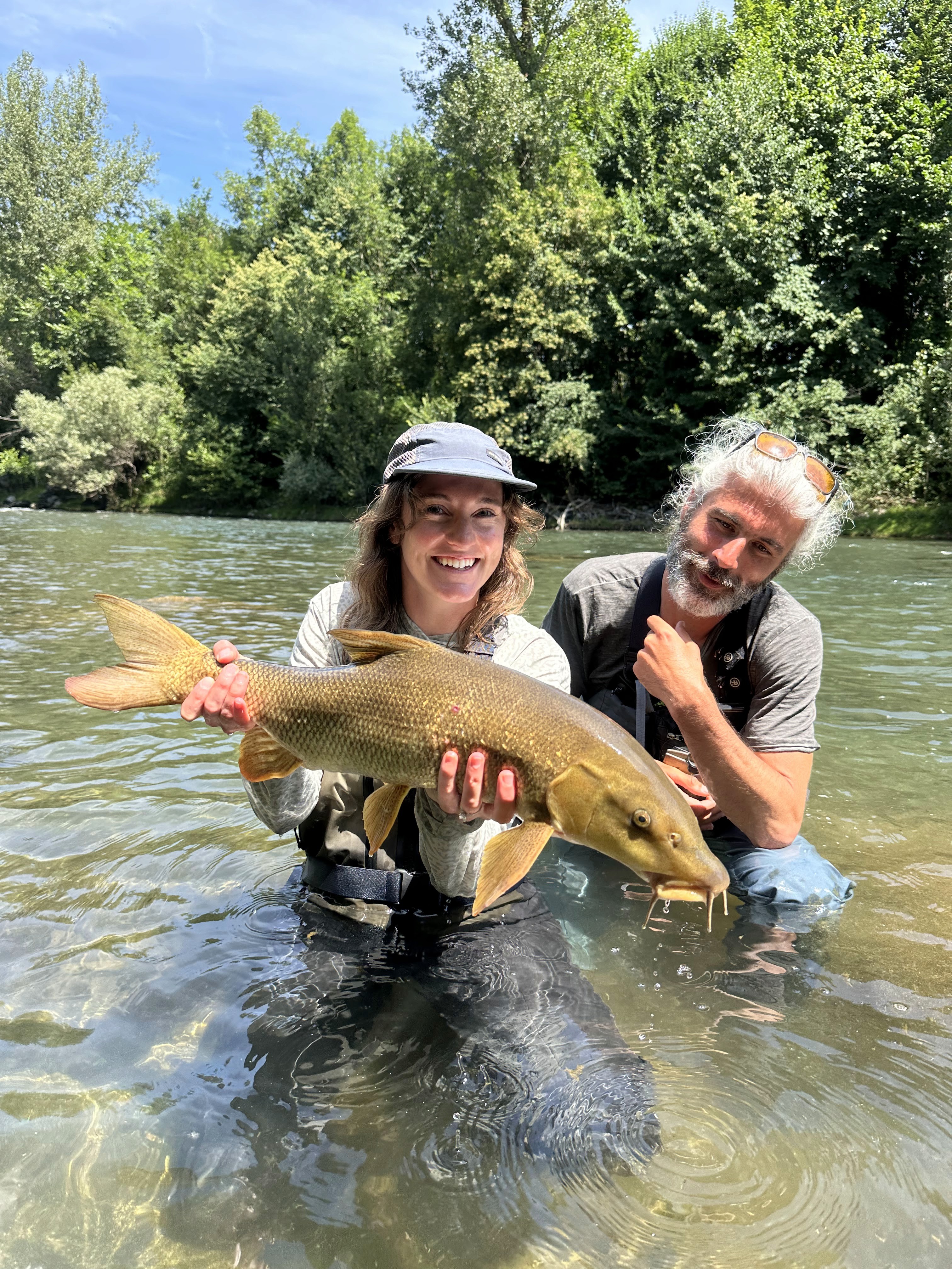 Big trout from the Ariège: an angler proudly displaying a large catch from a clear Pyrenean river.