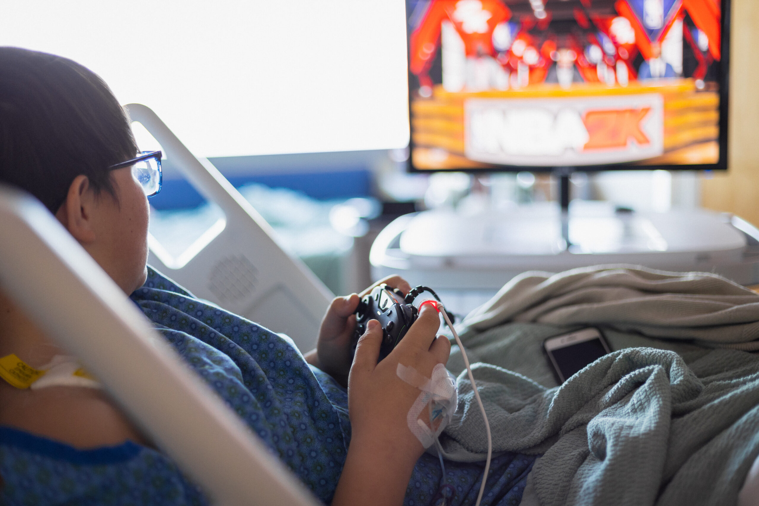 A child in a hospital plays on Gamers Outreach device.