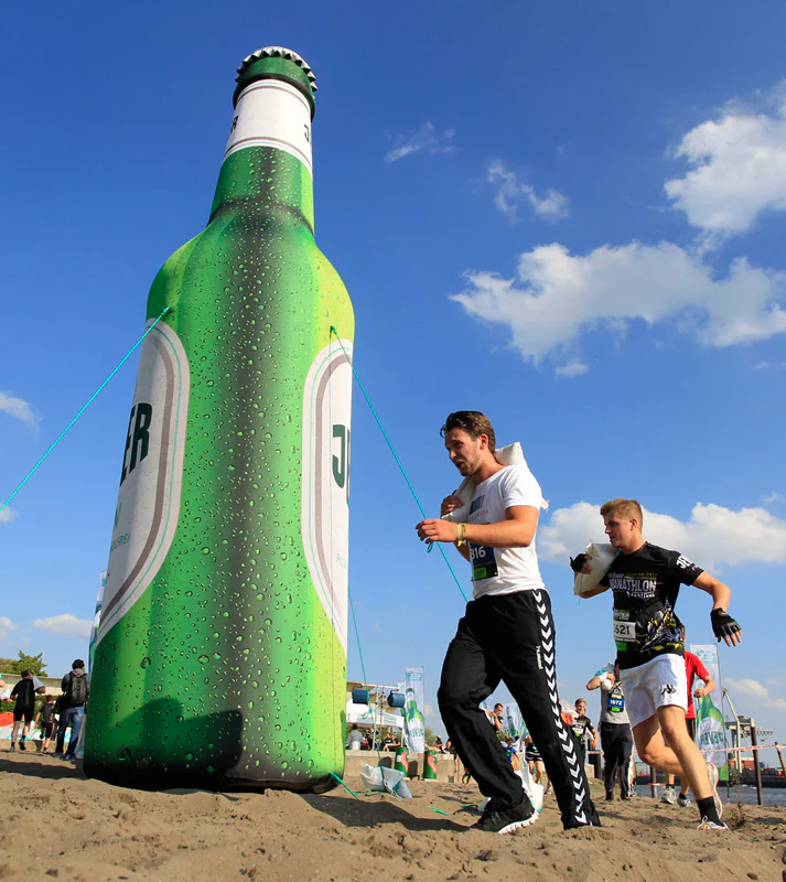 People running around a giant inflatable bottle