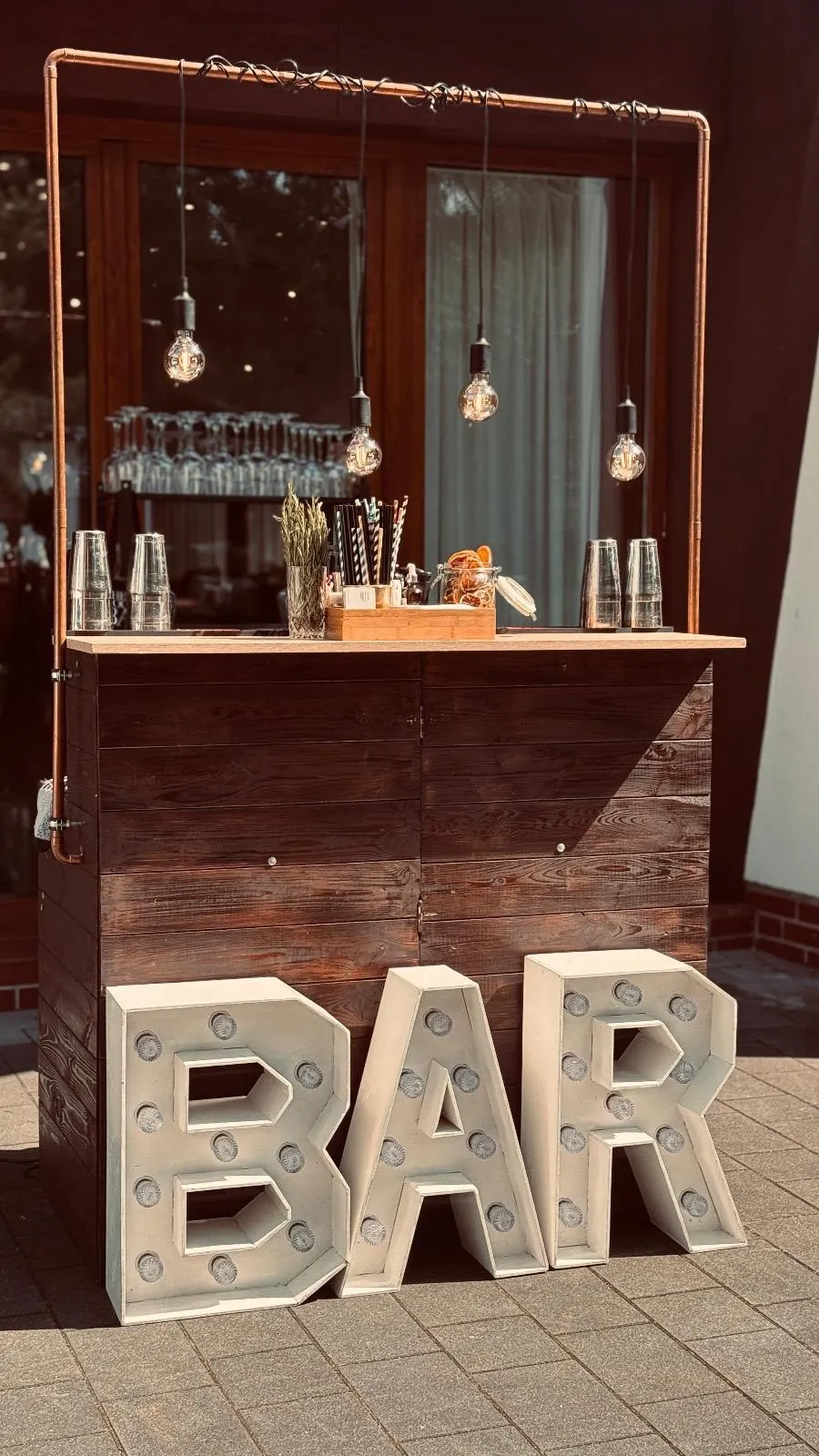 Barman na weselu pokazuje sztuczki barmańskie przed zgromadzonymi gośćmi podczas pokazu barmańskiego