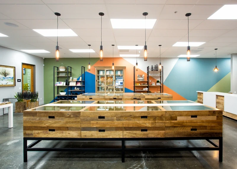 Kannabis Works retail area with rustic display cases, colorful accent walls, and bright lighting.