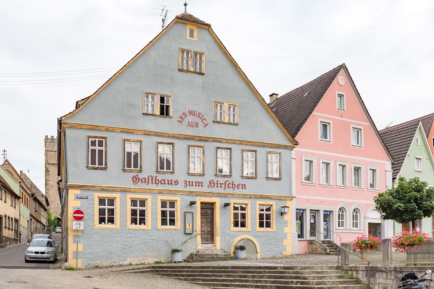 Fotografie des blauen Bürgerhauses Ars Musica in Aub an einem bewölktem Tag.