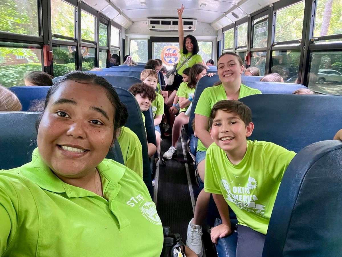 Selfie of a counselor and camp kids on a bus going to a field trip.
