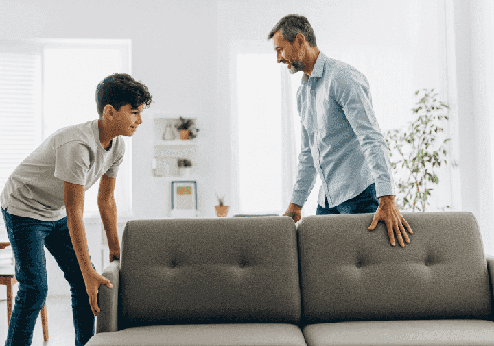 Nastolatek pomaga tacie w przeniesieniu sofy