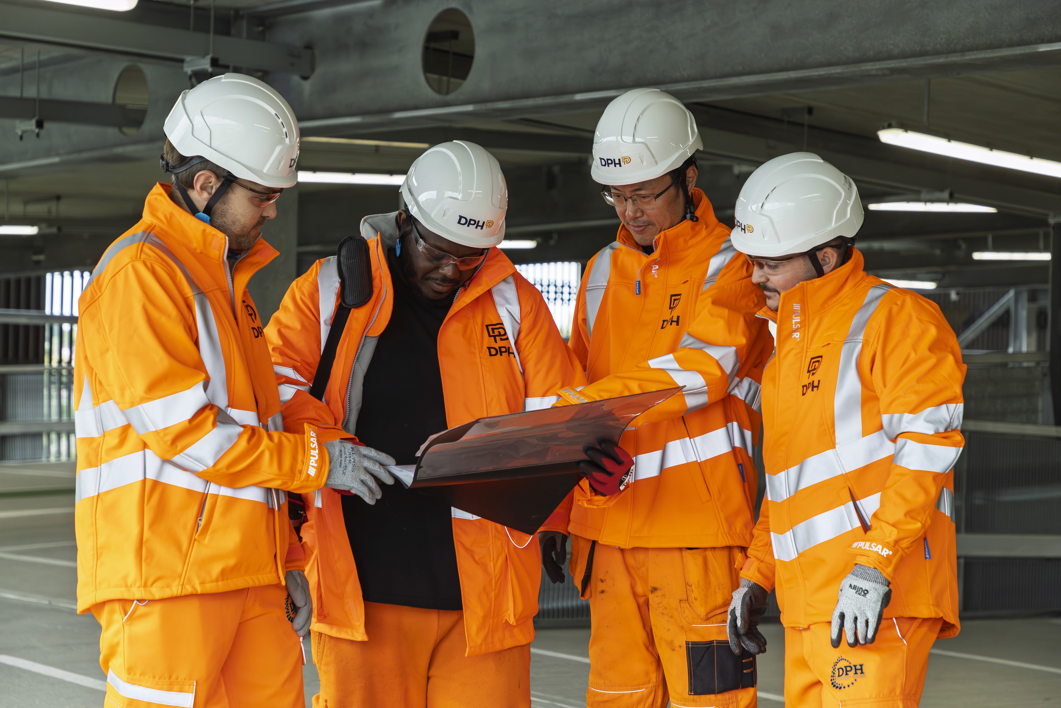 Modern glass building with illuminated trees and a view of city skyscrapers