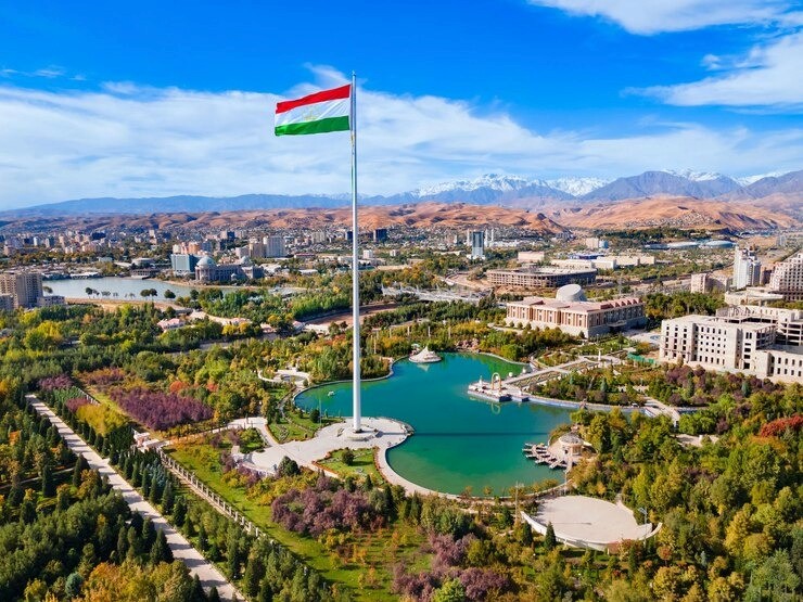 red train travelling near body of water