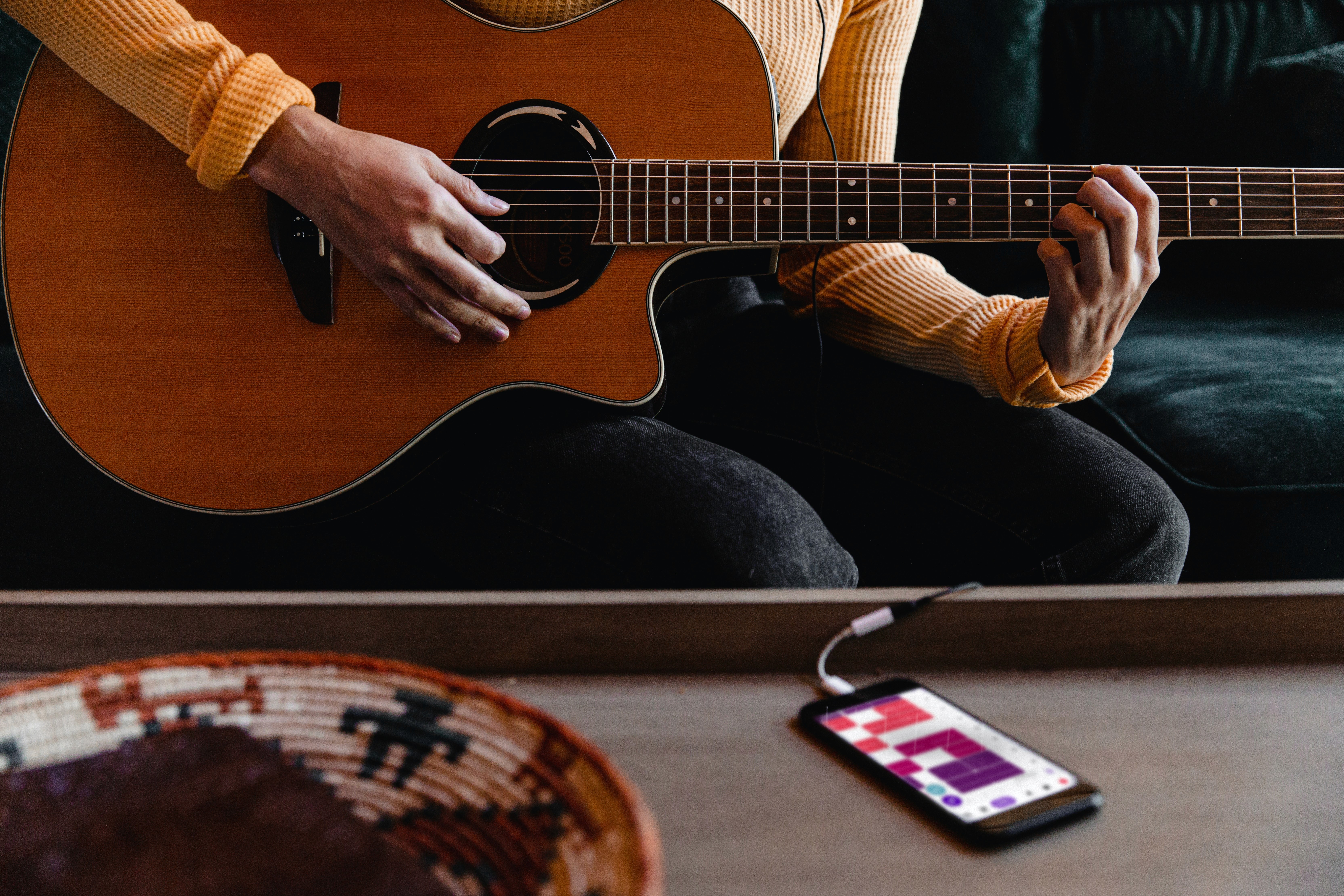 Woman recording with guitar - soundful vs musicfy