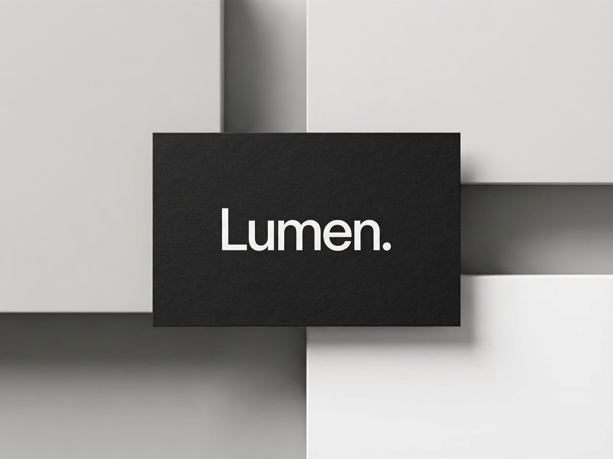Mockup of Lumen logo in white minimalist typography on black textured card, placed over a modern geometric gray background.