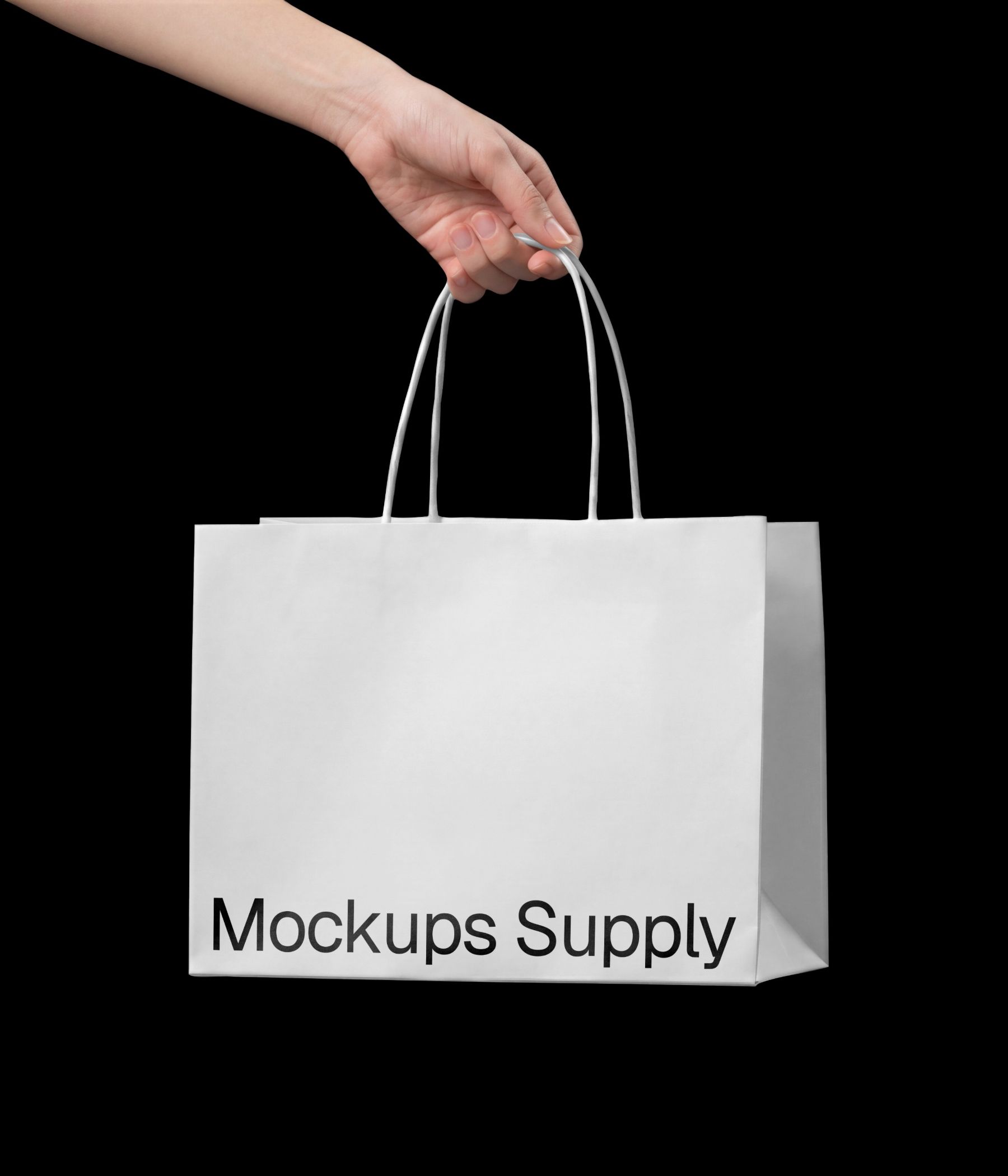 Hand holding wide paper bag mockup with twisted handle against a clean black background