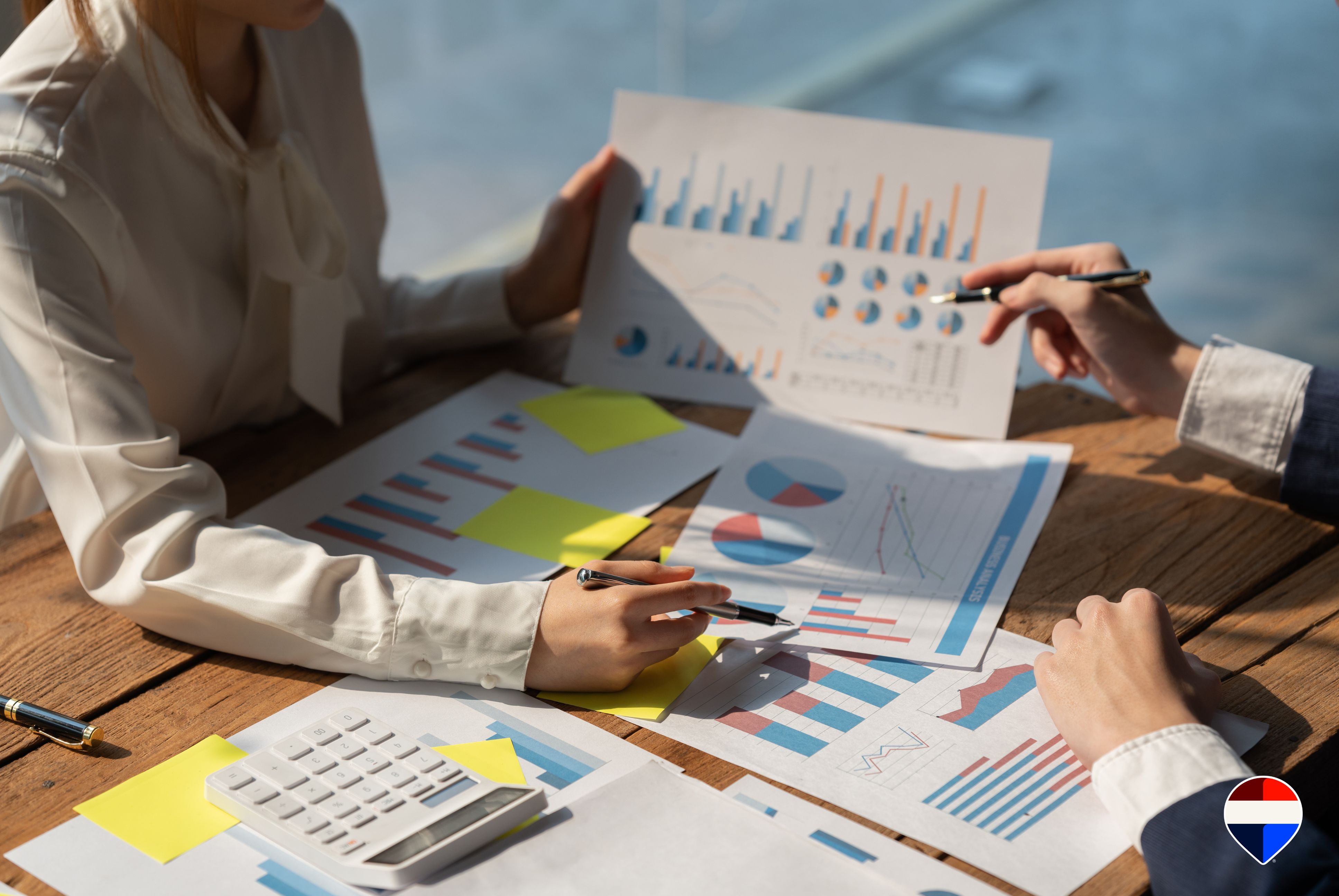 Agente immobiliare che illustra al proprietario il report mensile con i dati sull'andamento della vendita