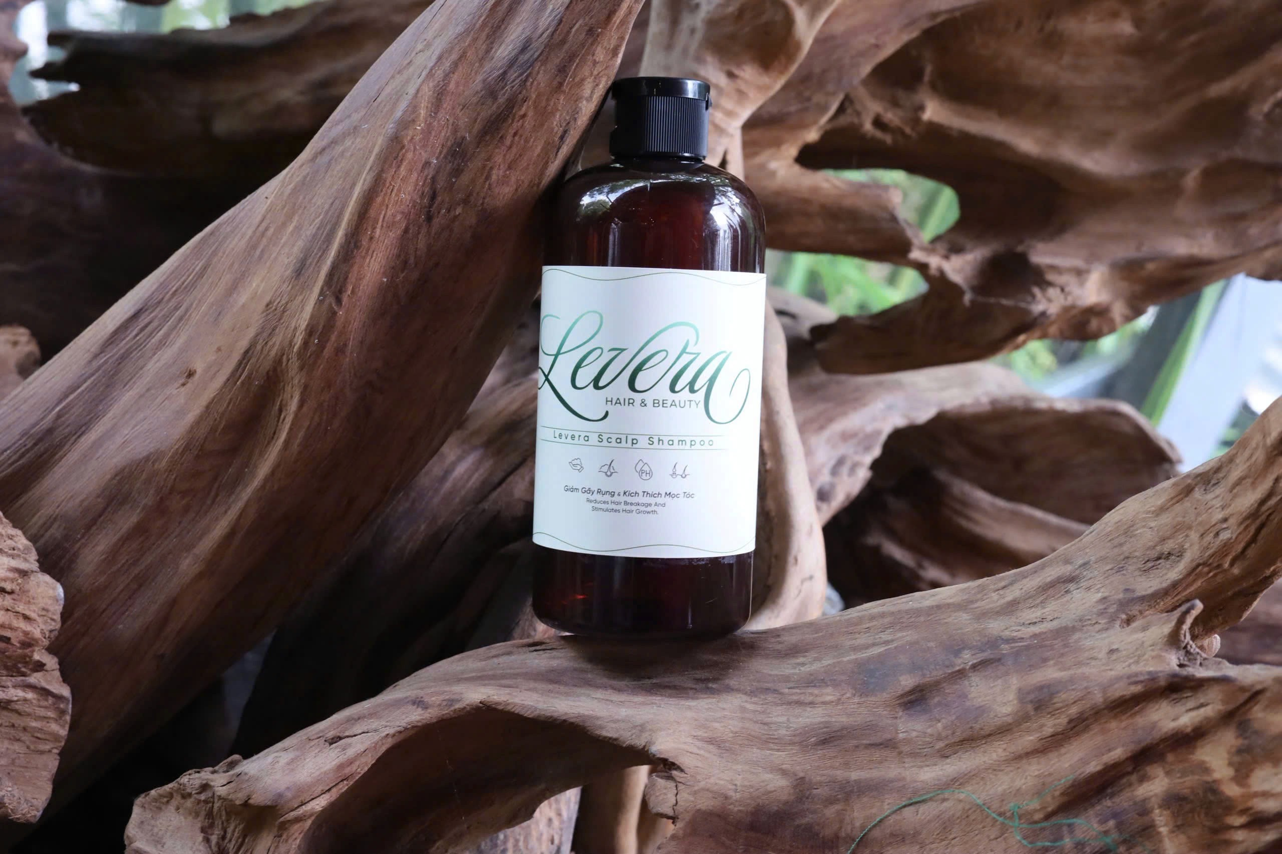 a bottle of broc cosmetics sits on a pile of branches