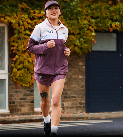 Person jogging on a street with trees around.