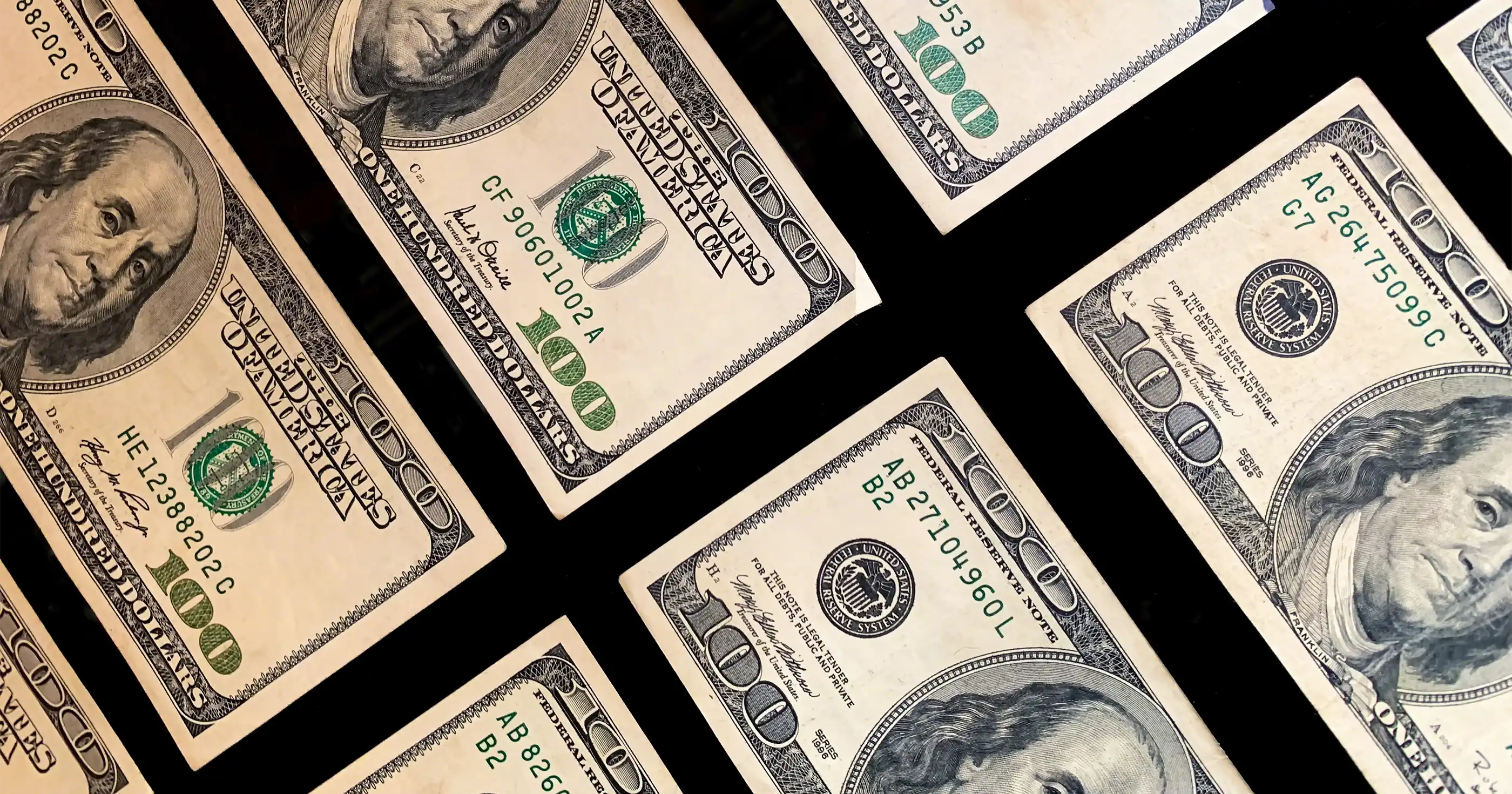 several hundred dollar bills neatly organized in rows