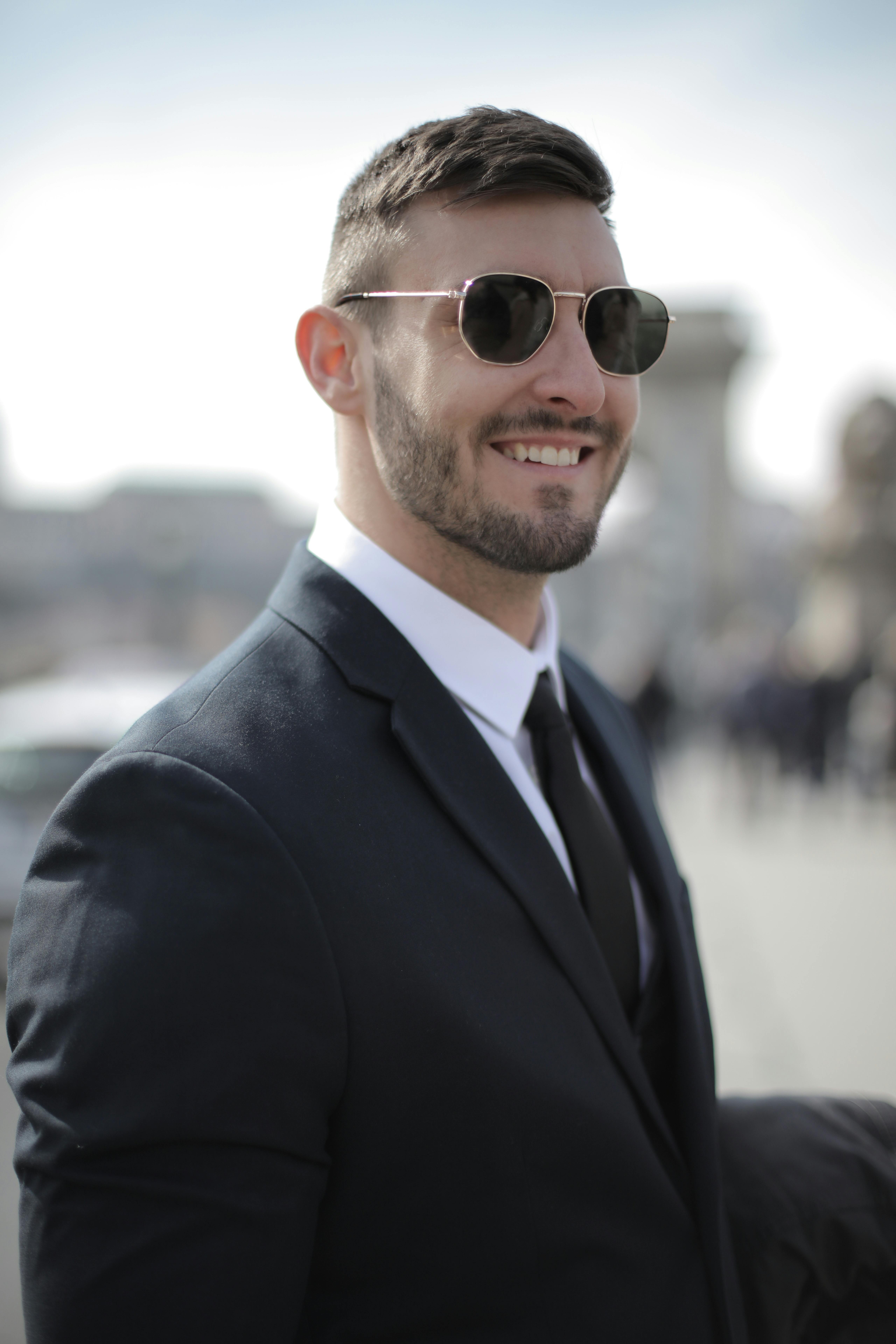smiling-businessman-outdoors-wearing-a-black-suit-and-sunglasses,-exuding-confid - andrea-piacquadio (pexels)