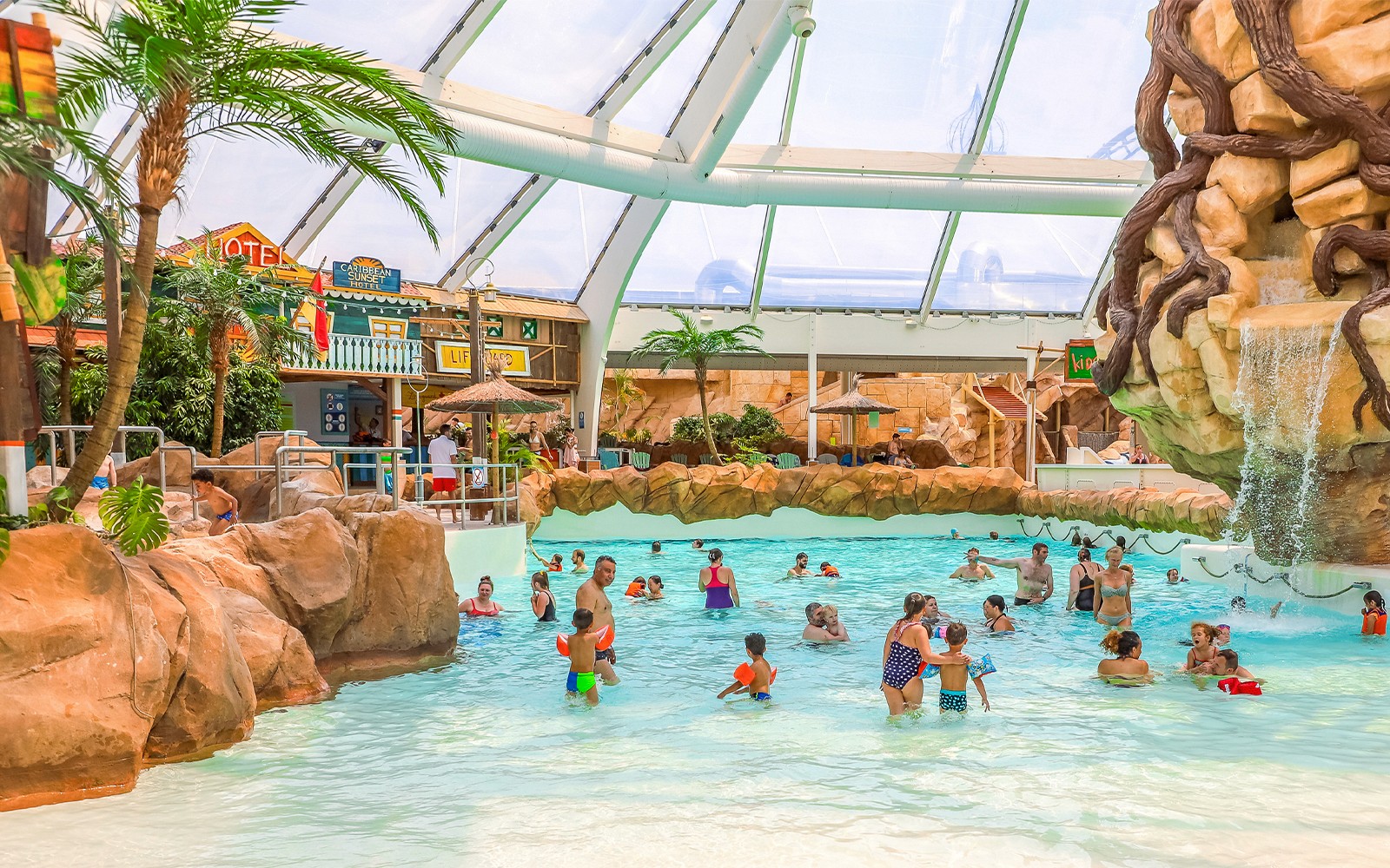Tourists enjoying the wave pool at Aqualibi indoor water park.