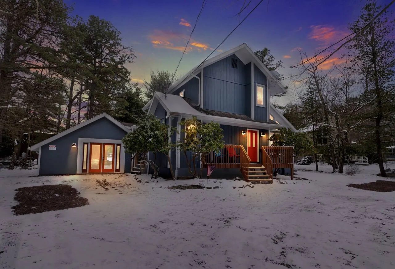 Home lit at dusk with snow on the ground at Beechwood Bliss, Lake Harmony, PA
