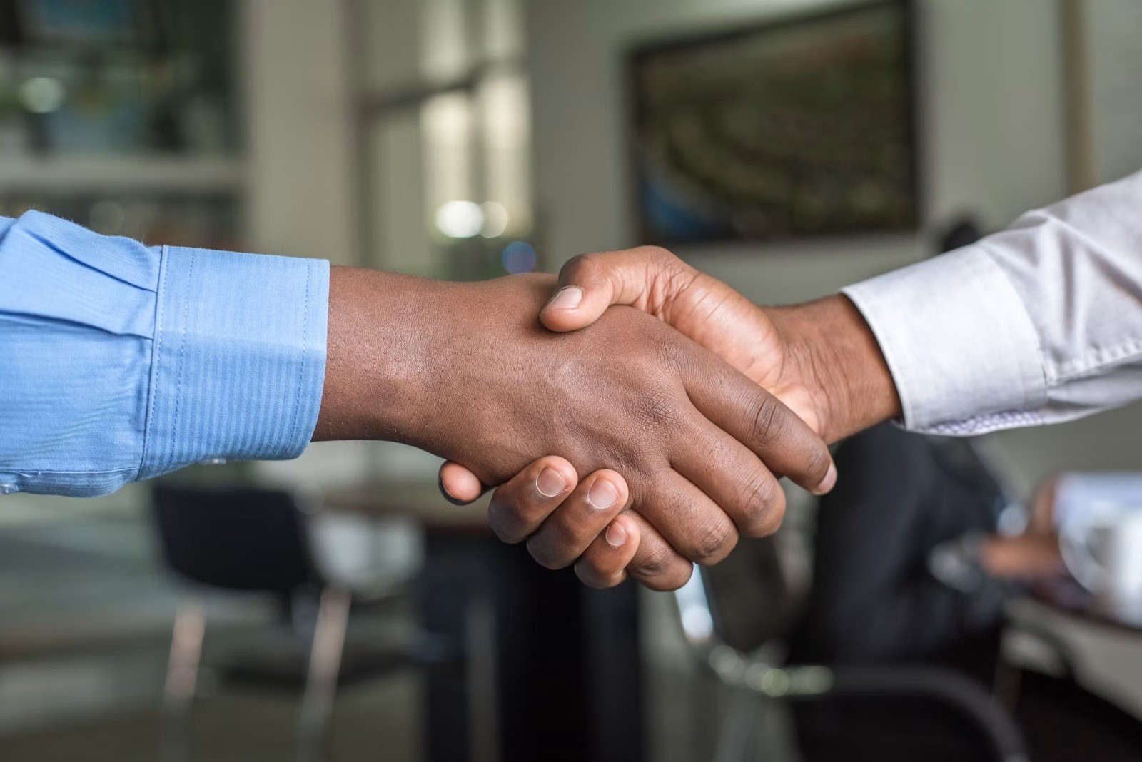 Handschlag nach einem Gespräch am Besprechungstisch