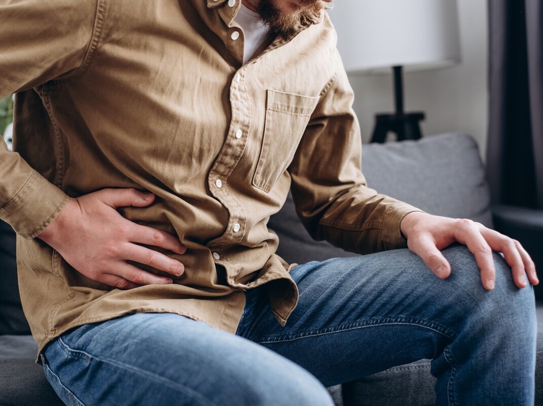 man having stomach pain from side effects from taking a famous weight loss drug