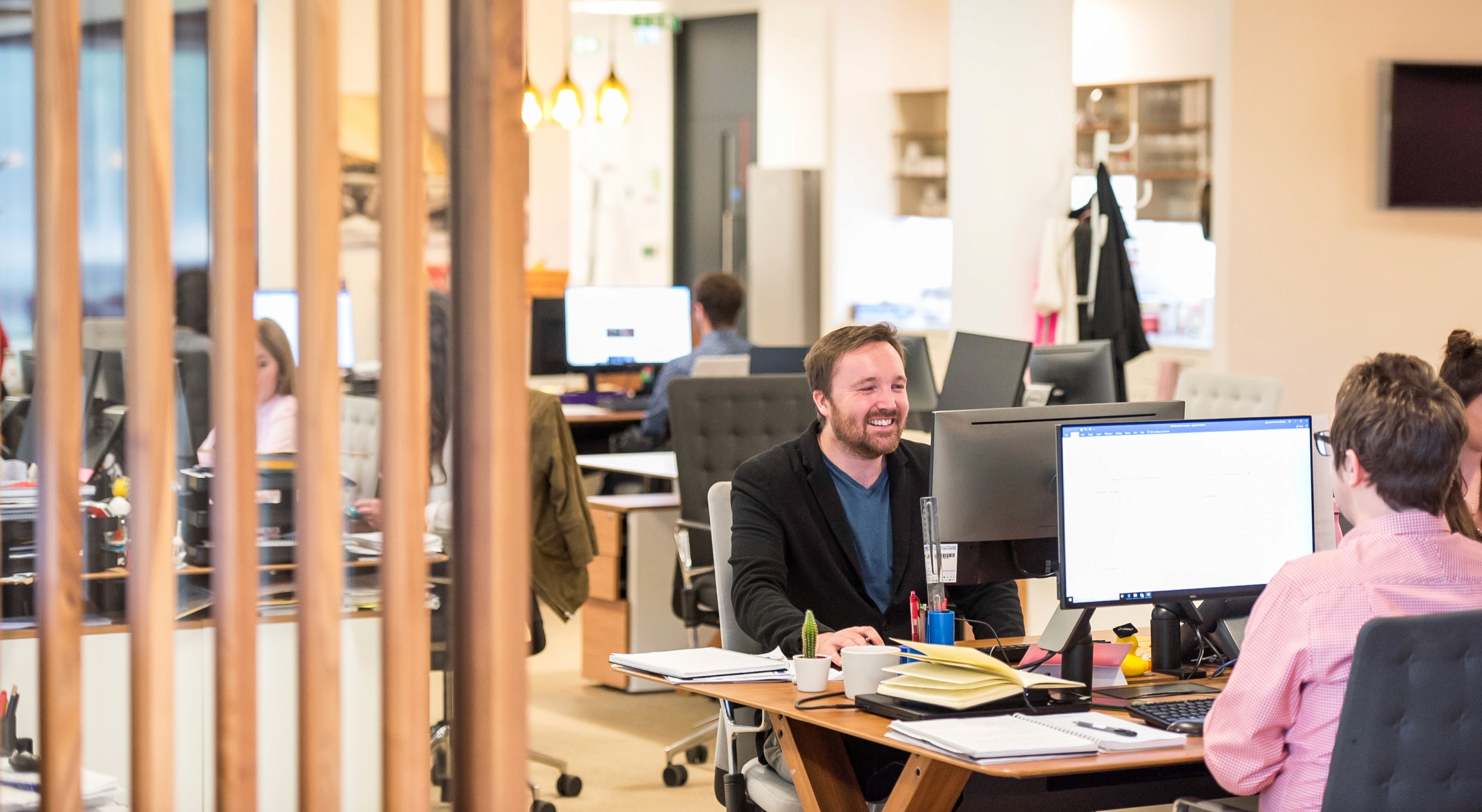 Man Smiling at Desk in Office
