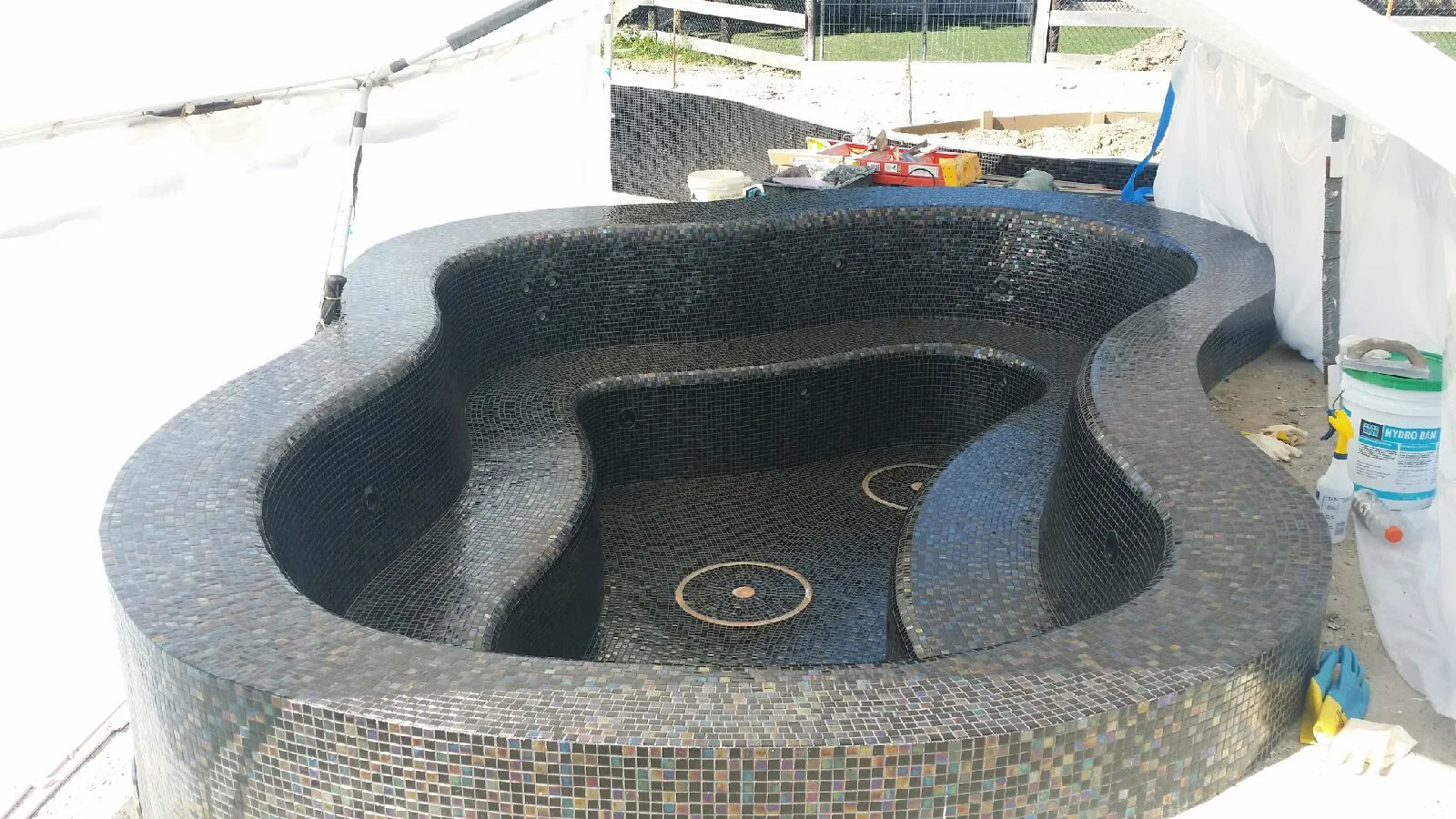 The spa at Barrington Hills mid-construction, every curved surface hand-tiled in the Nocturne and Obsidian blend.
