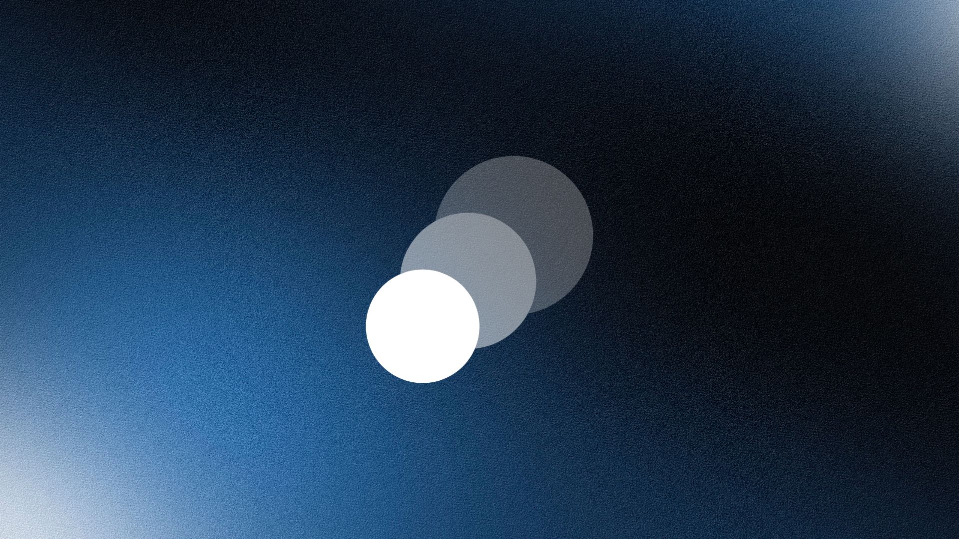 Smiling woman wearing a beige blazer and grey shirt, holding a folder while standing by a sunlit wall.