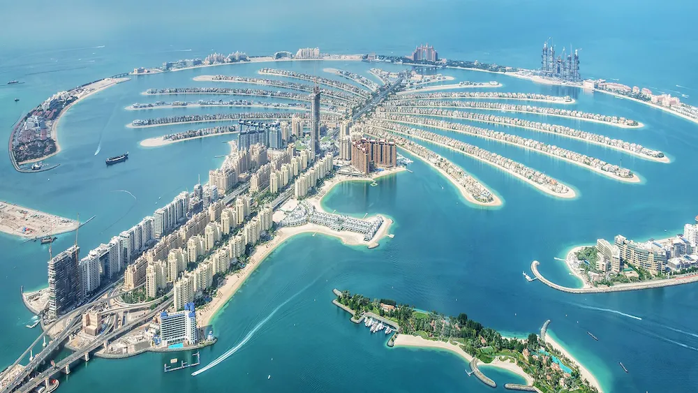 green chairs under umbrellas on shore