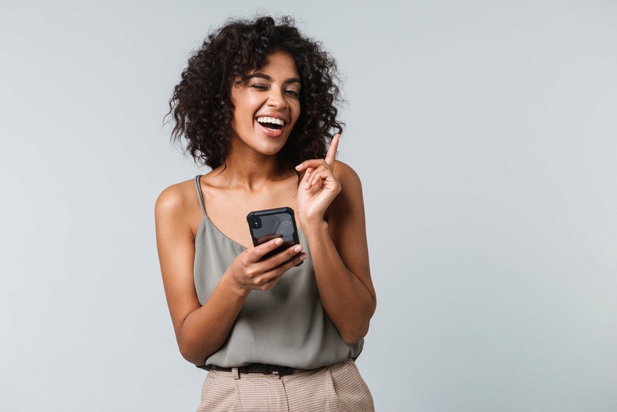 mulher sorrindo segurando celular